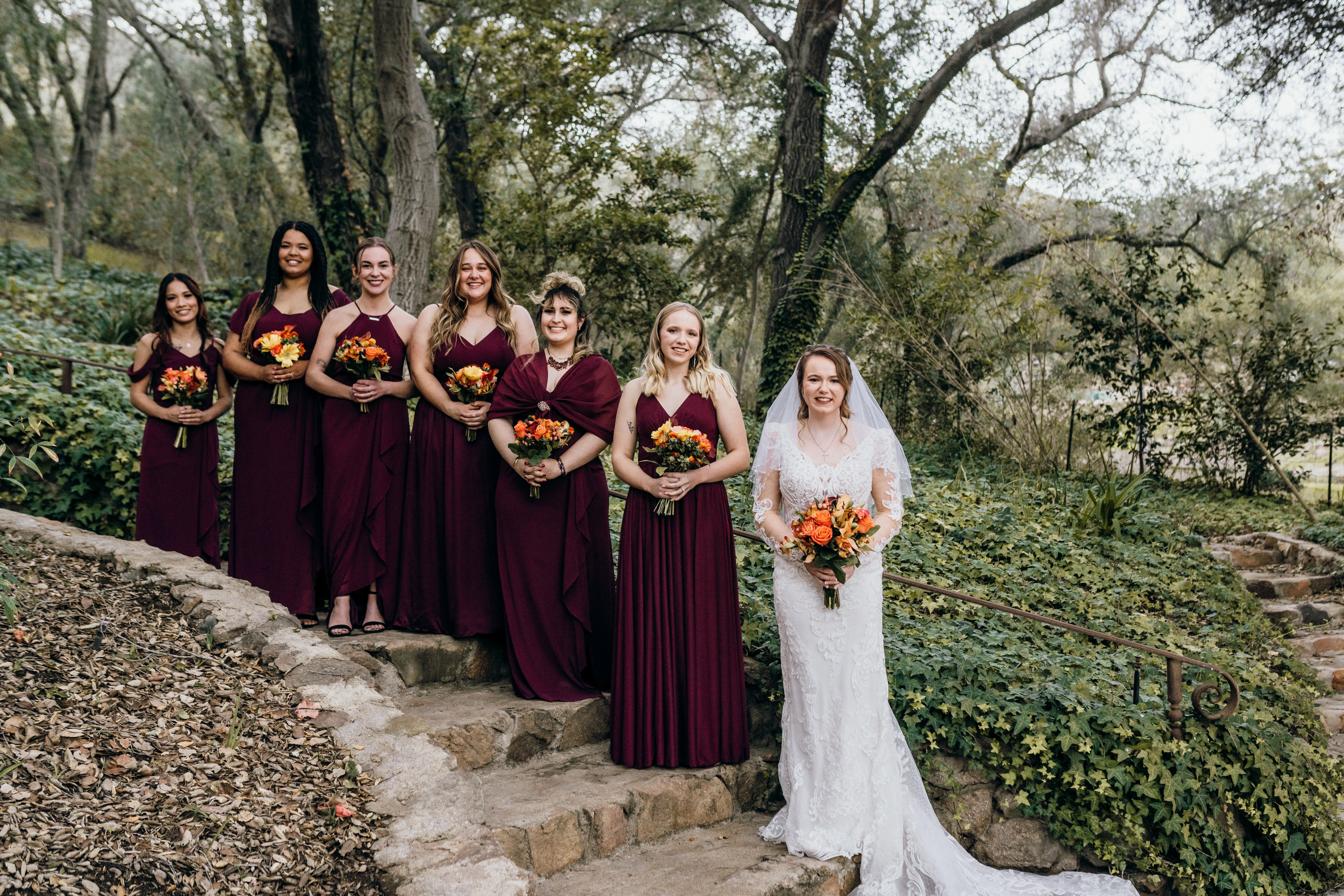 Bride In Embroidered Lace Sheath Dress Hamilton Sottero Midgley With Bridesmaids in Wine