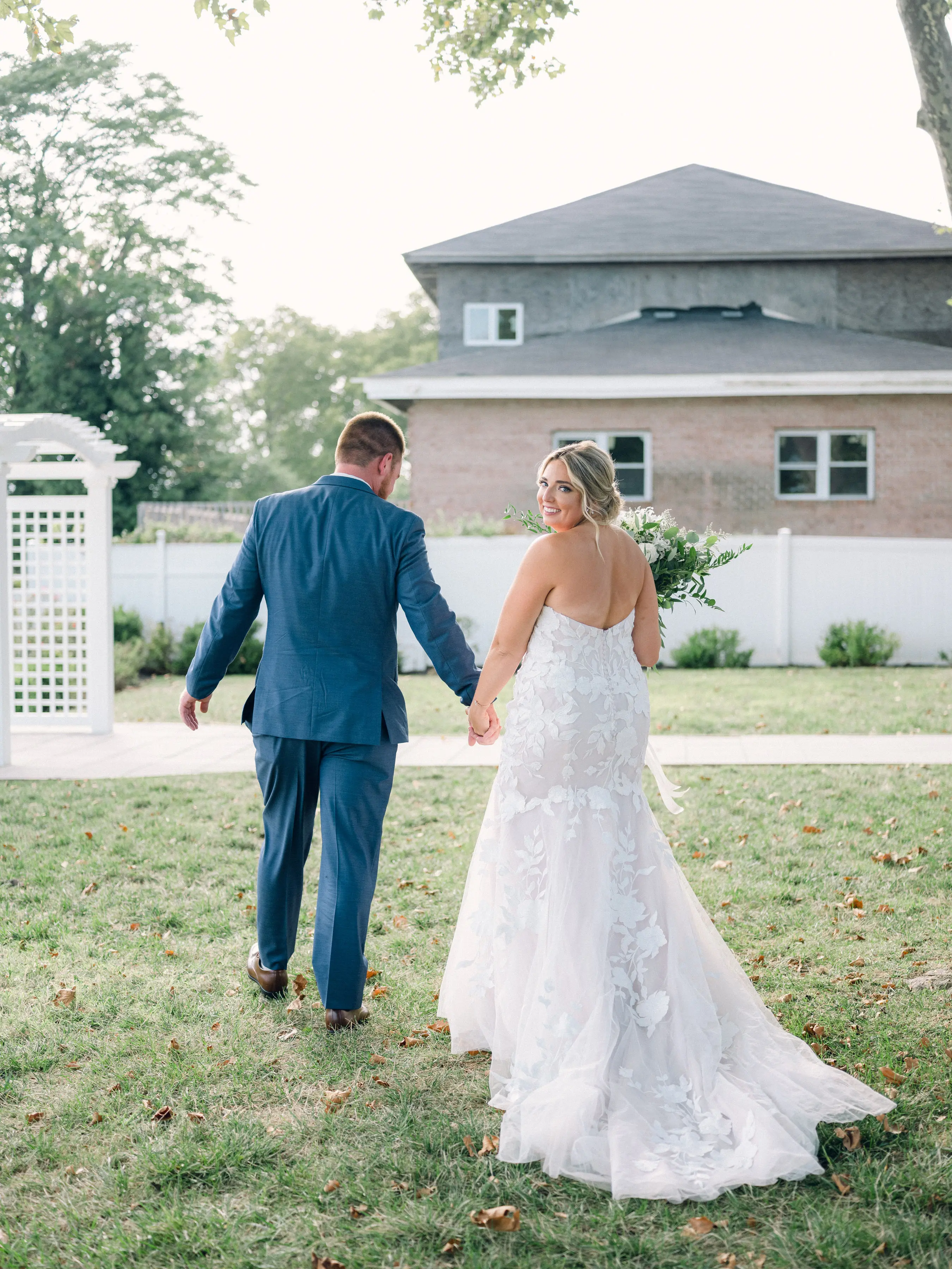 Bride Wearing Lace Mermaid Wedding Gown Called Hattie By Rebecca Ingram Holding Hands With Groom