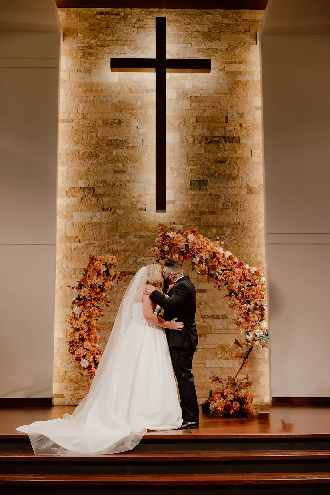 Bride wearing Derrick by Maggie Sottero kissing her husband at their ceremony
