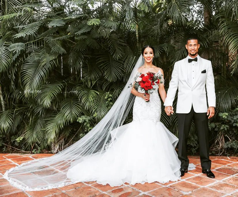 Bride with groom wearing glamorous mermaid wedding dress