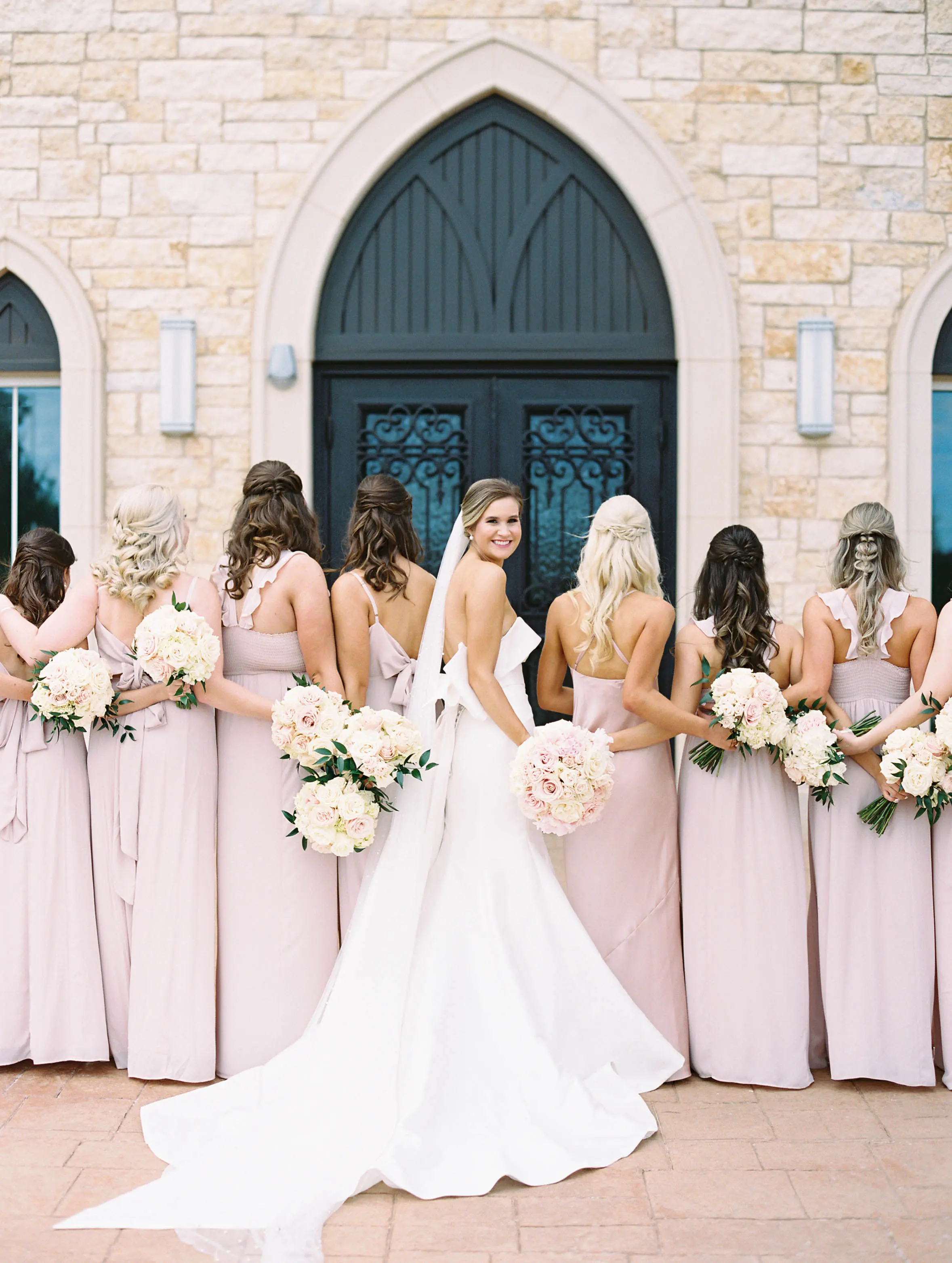Bridesmaids With Bride Wearing Simple Sheath Wedding Dress With Bow Back Called Mitchell By Maggie Sottero