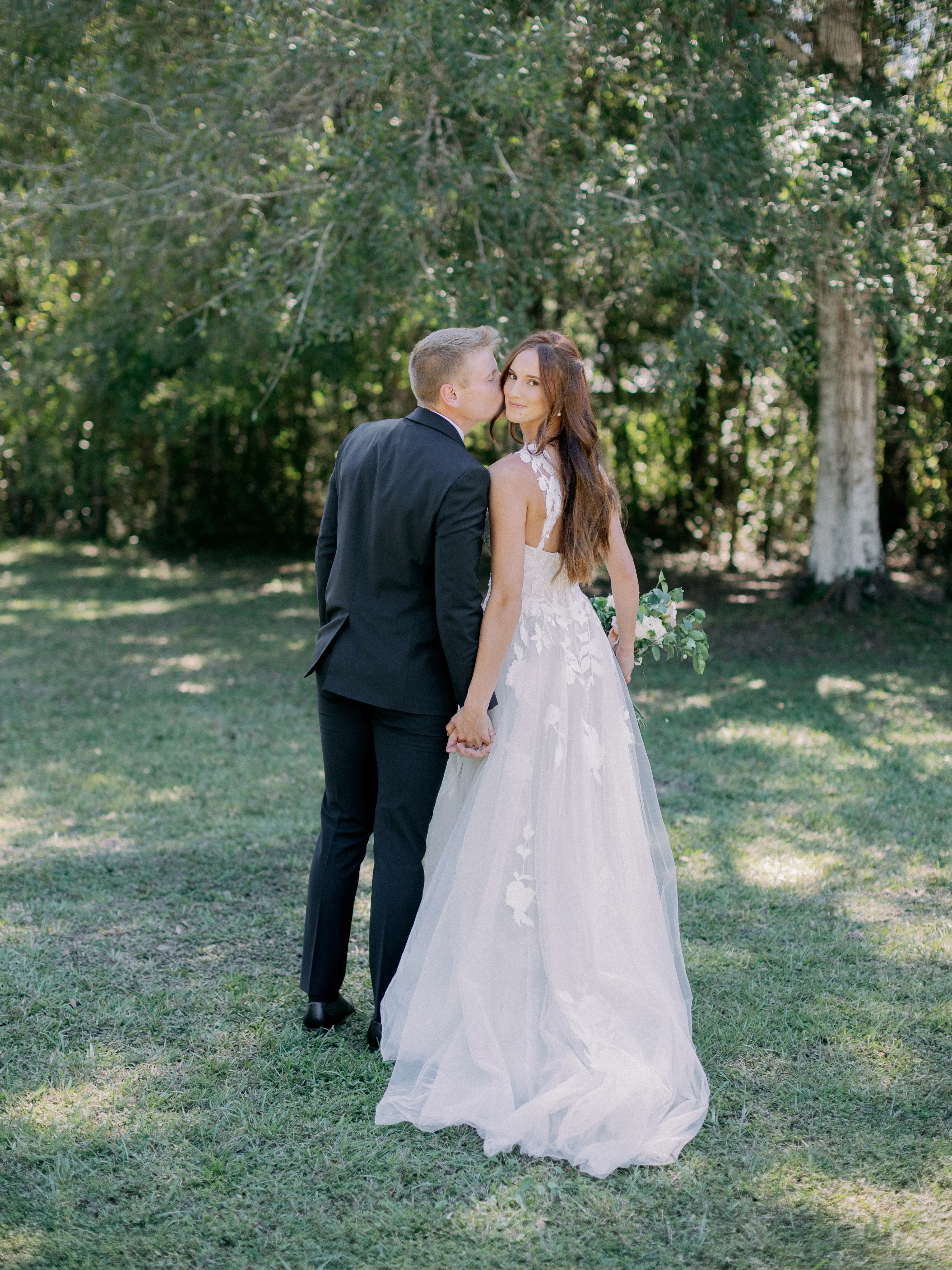 Bride Wearing Plunging V-Neckline Bridal Dress Named Hattie Lane Marie By Rebecca Ingram Groom Kissing Bride