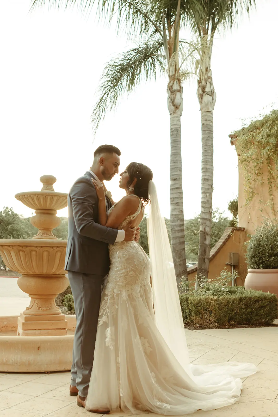 Bride and groom hugging close looking into each other's eyes.