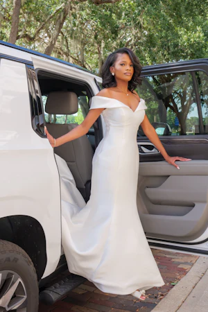 Bride Wearing Simple Mermaid Wedding Dress Called Josie By Rebecca Ingram Getting Out Of A SUV
