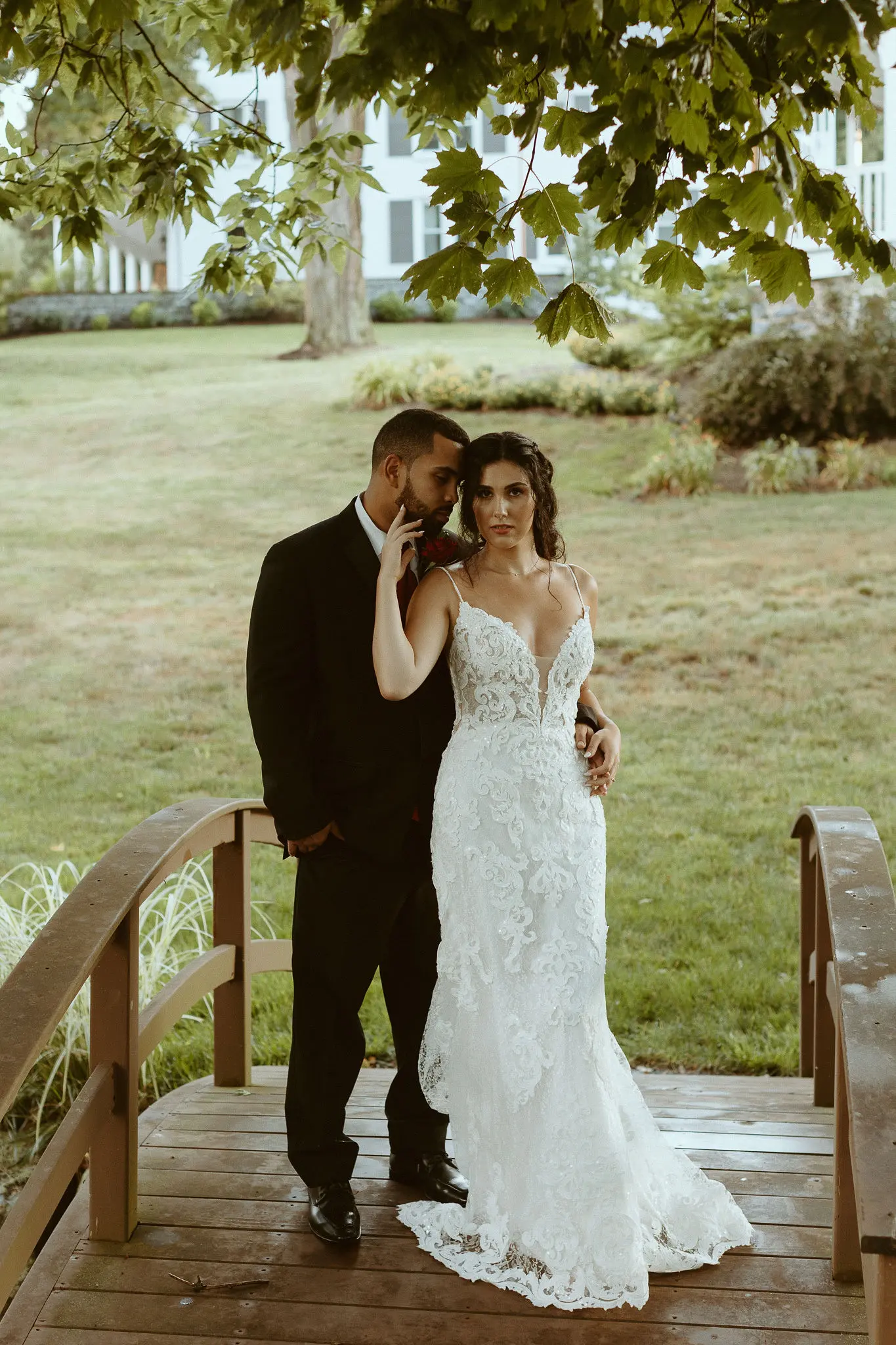 Bride with groom wearing lace sheath wedding dress.