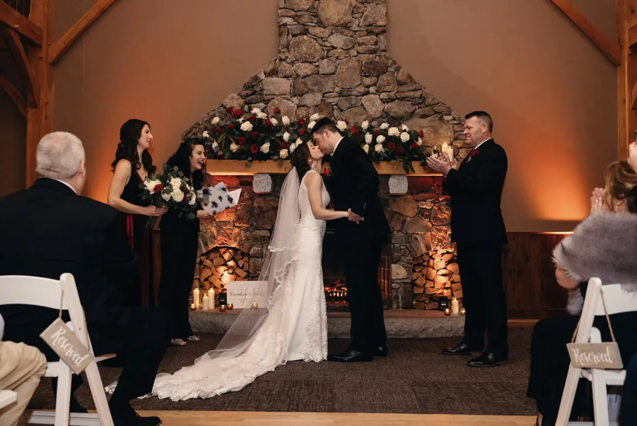 Bride Wearing Lace Halter Wedding Gown Called Kevyn By Sottero And Midgley Kissing The Groom As Husband And Wife
