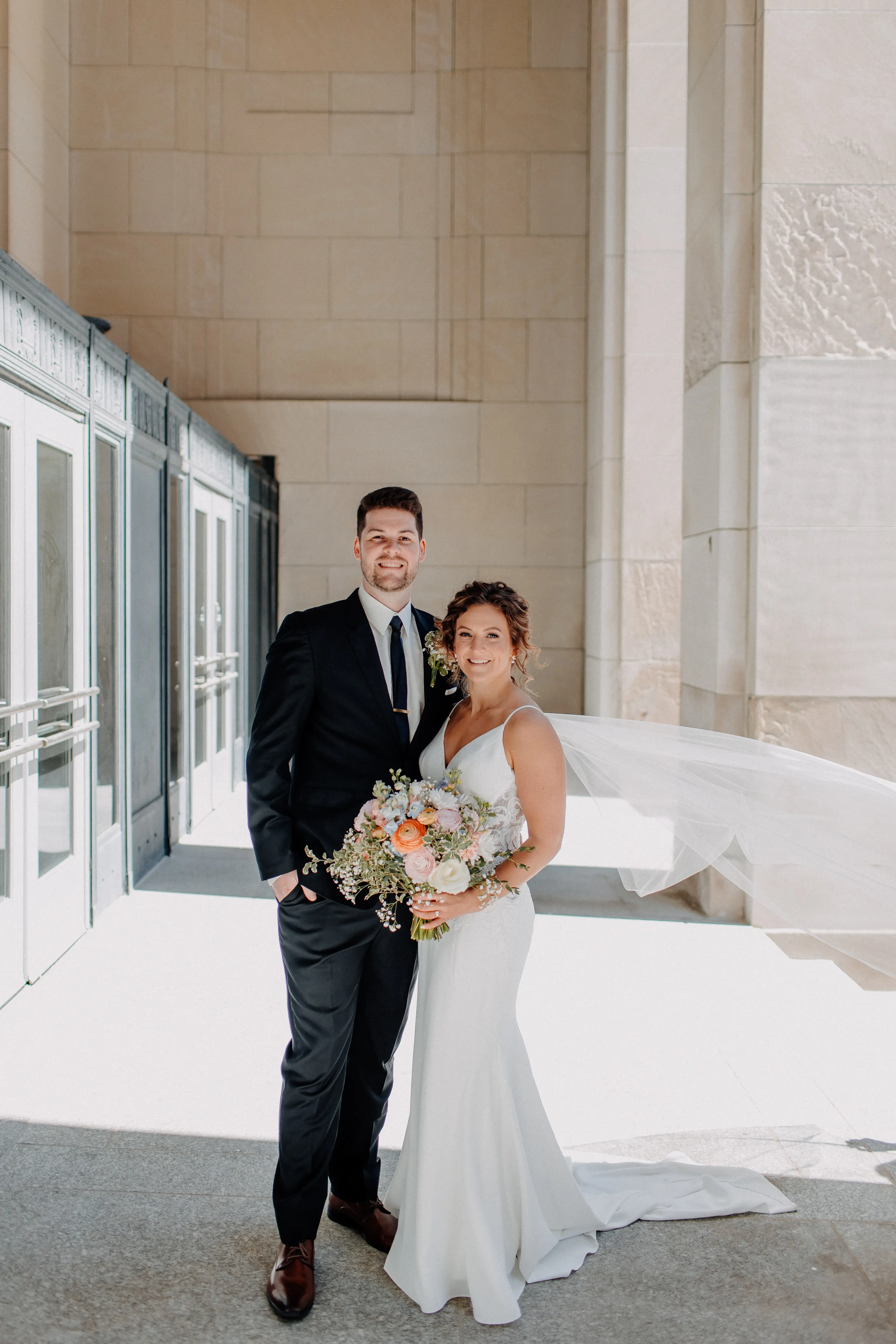 Bride wearing Dionne by Rebecca Ingram standing with her husband outside