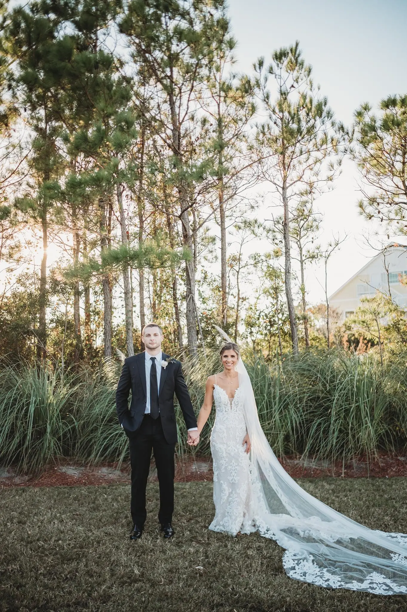 Groom Holding Hands with Bride in Mermaid Wedding Dress with Shimmering Lace Motifs and Illusion Plunging Sweetheart Neckline Called Tuscany by Maggie Sottero