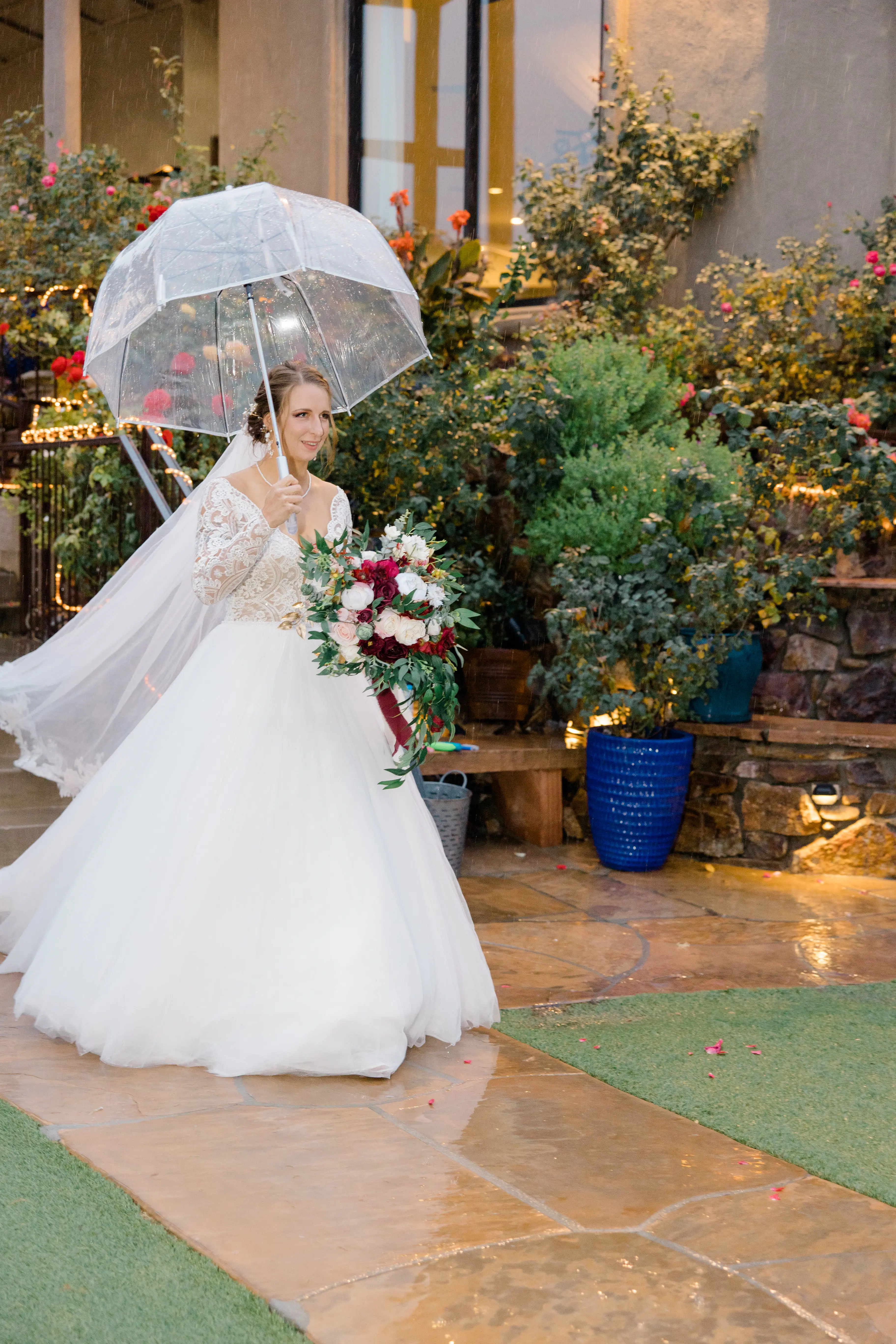Bride Under Umbrella on Rainy Wedding Day in Romantic Long Sleeve Ball Gown Wedding Dress with Lace Motifs on Nude Bodice and Tulle Skirt Called Mallory Dawn by Maggie Sottero