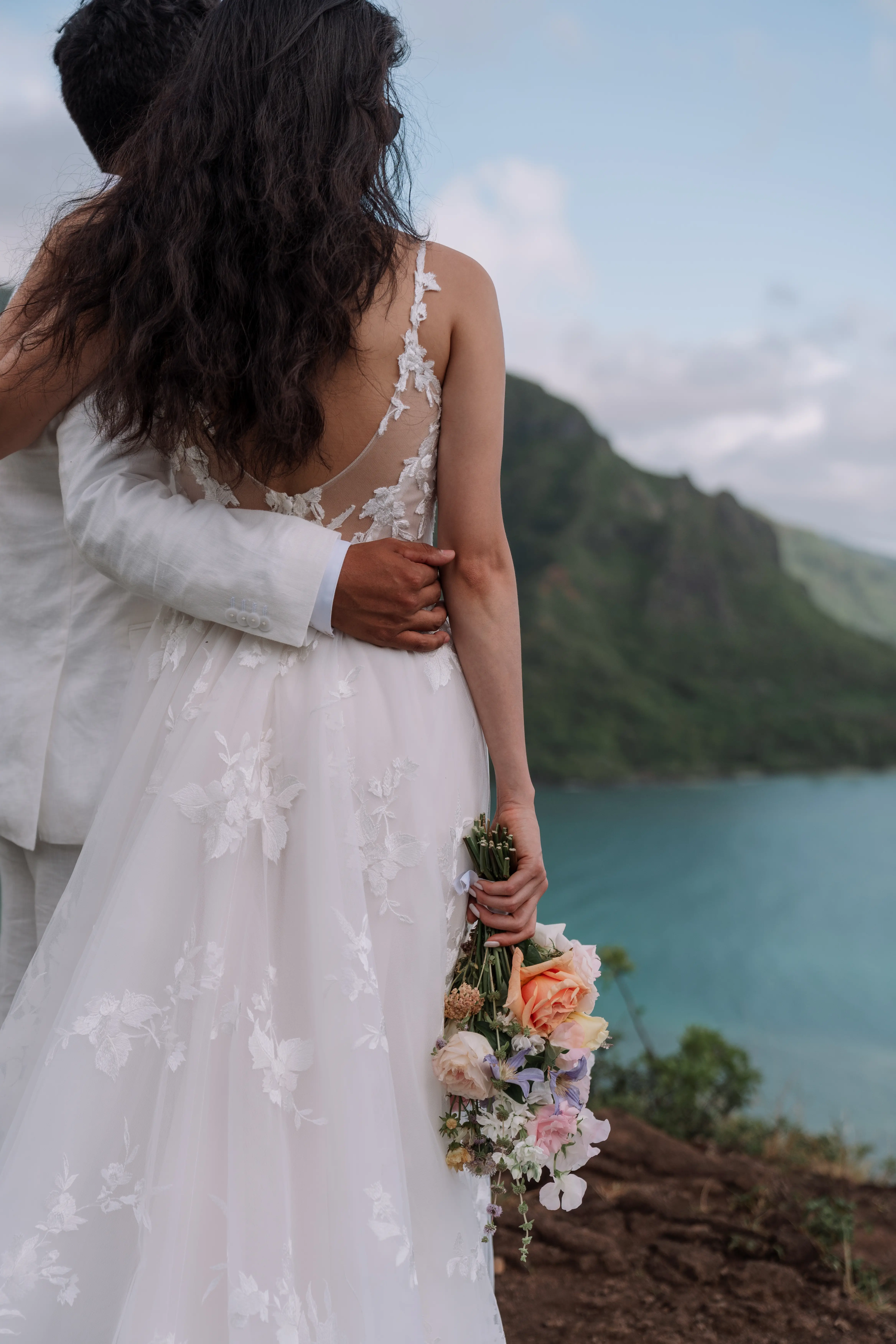Bride in Winter wedding dress hugs her husband