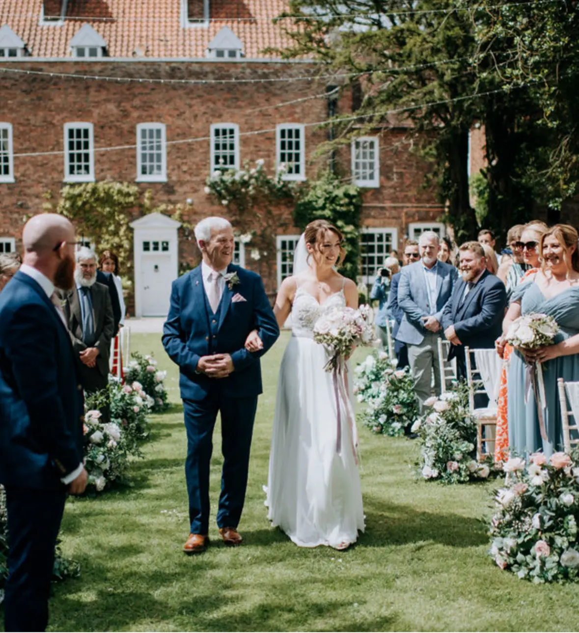 Bride wearing Lorraine by Rebecca Ingram being walked down the aisle