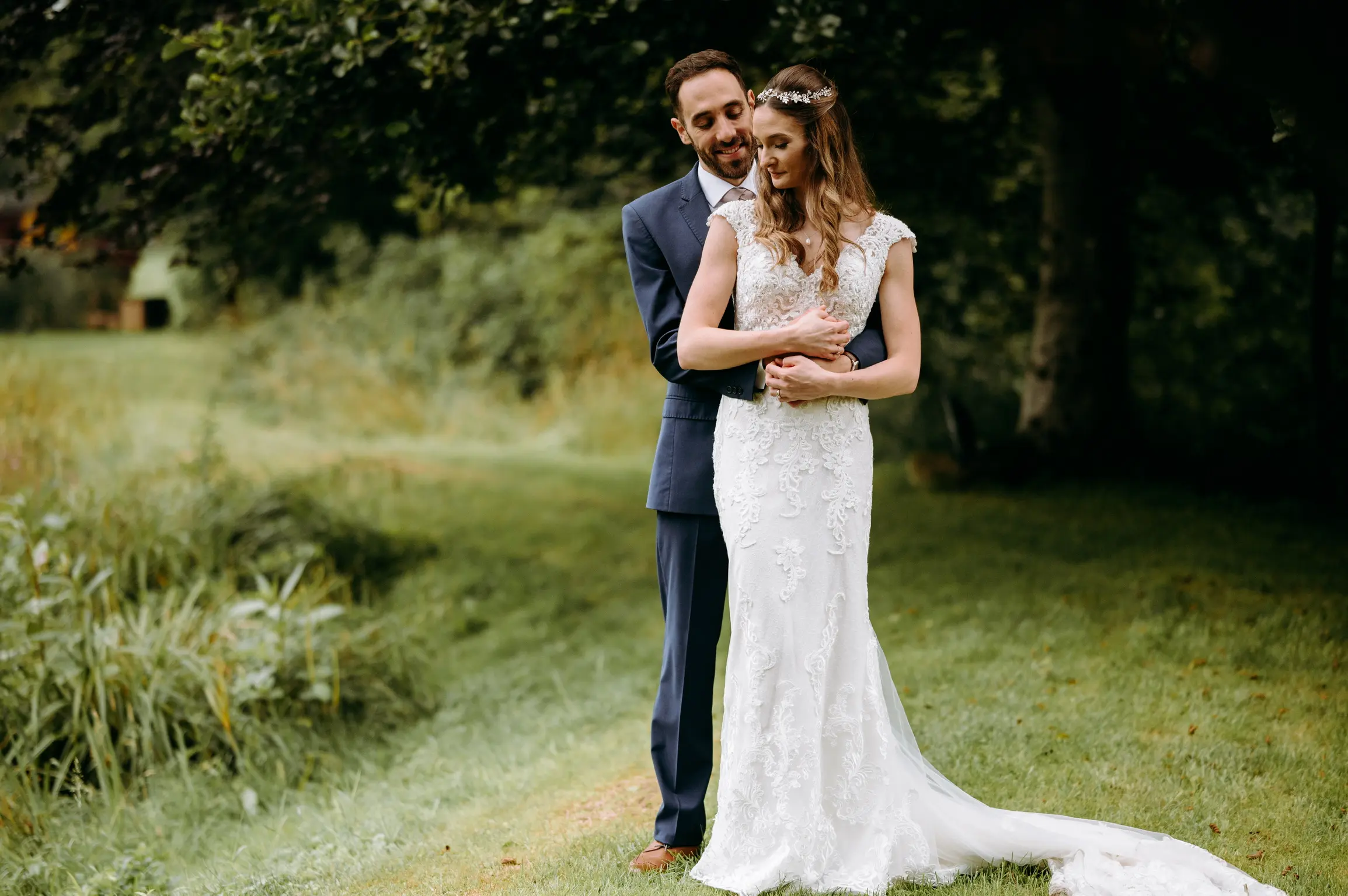 Groom with arms around bride wearing wedding dress called Celeste.