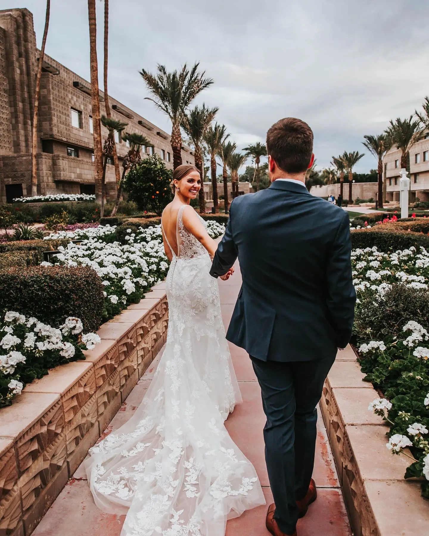 Groom Walking With Bride In Fit-And-Flare Floral Wedding Dress Called Greenley By Maggie Sottero
