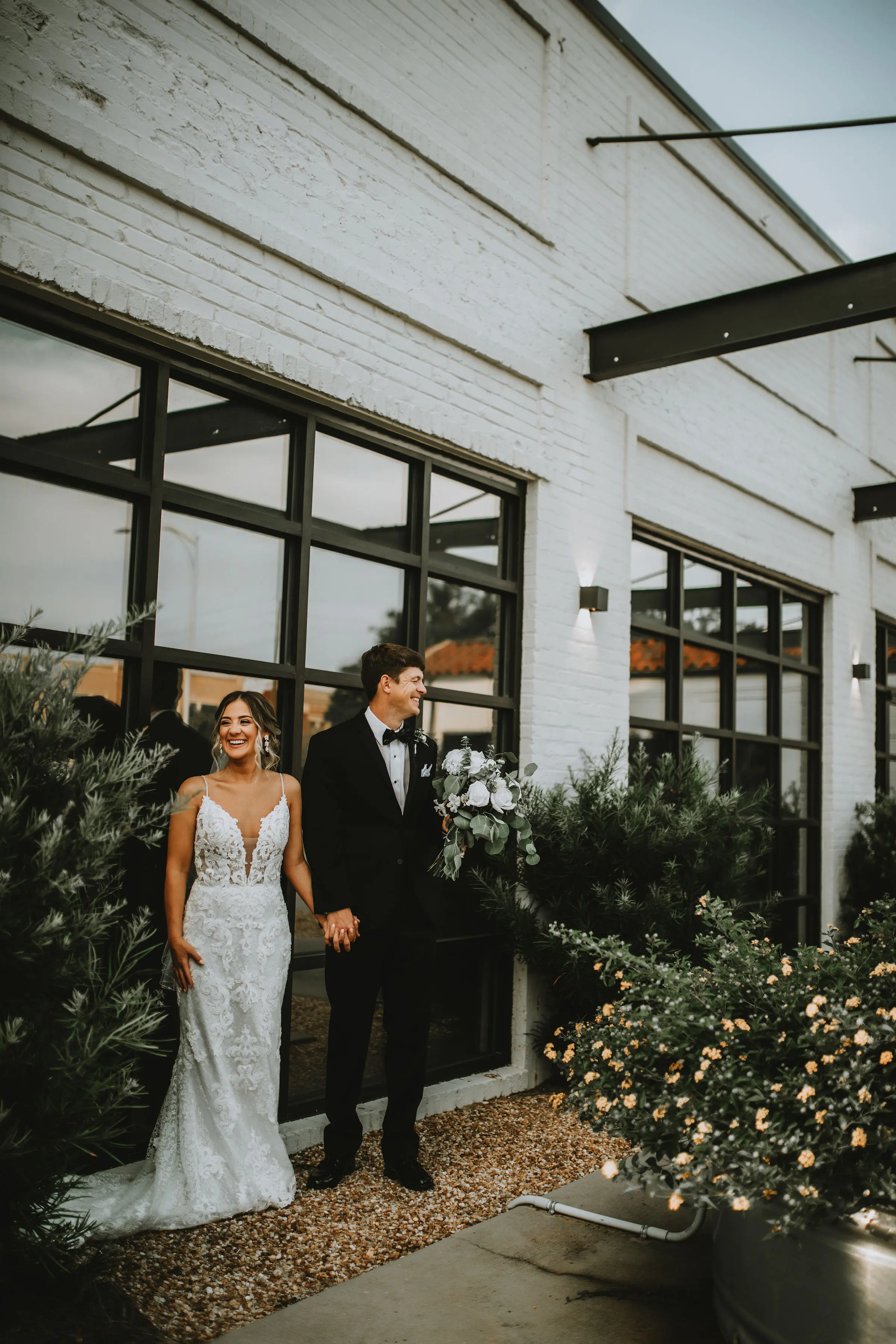 Bride with groom in romantic lace sheath wedding dress