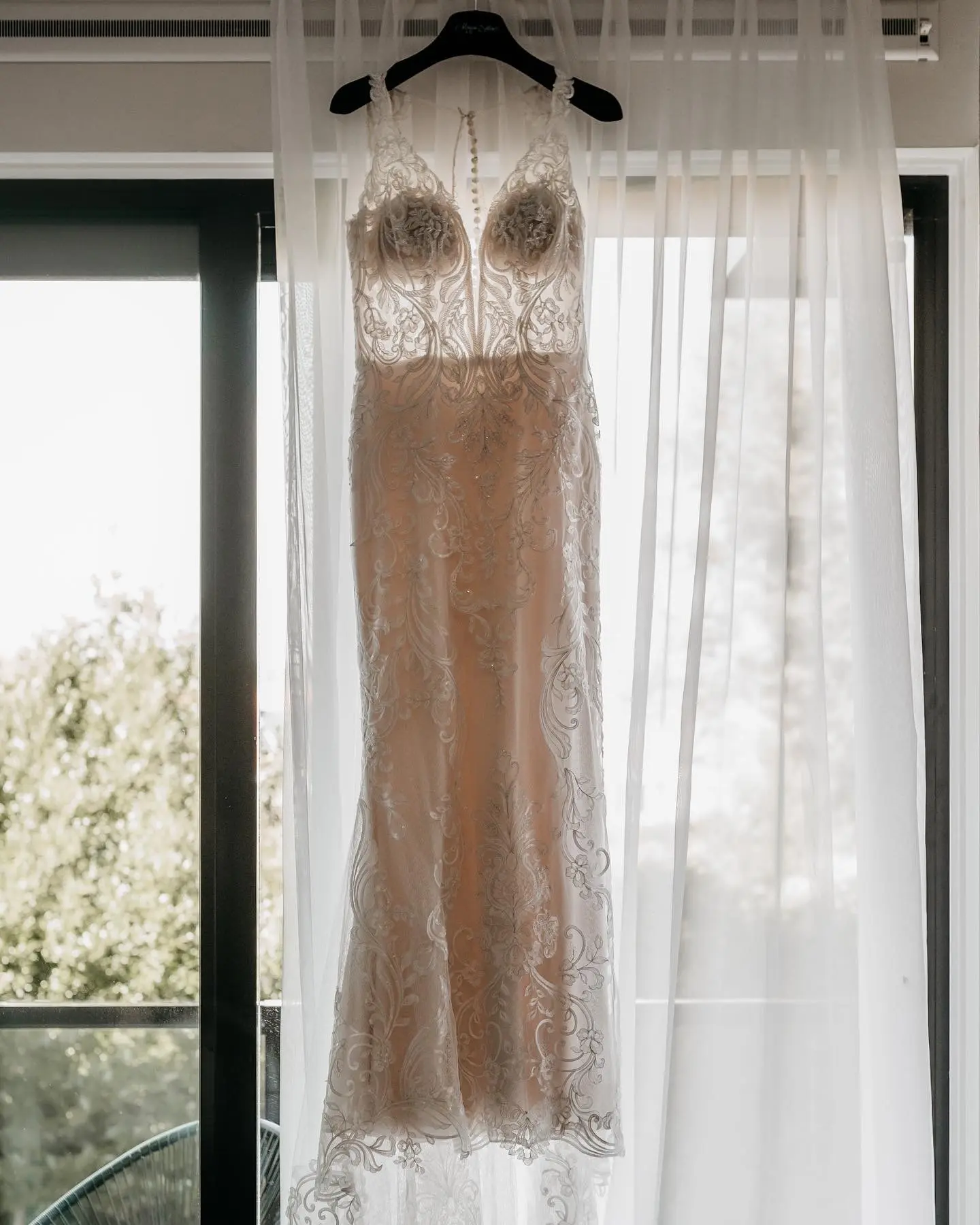 Lace Fit-And-Flare Wedding Dress Called Hamilton By Sottero And Midgley Hanging From A Window