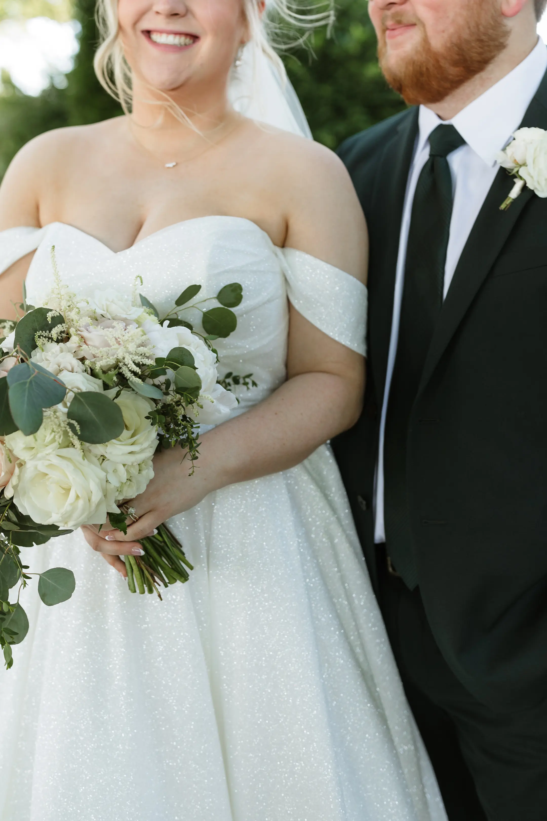 Bride wearing Anniston by Maggie Sottero holding her bouquet with her husband