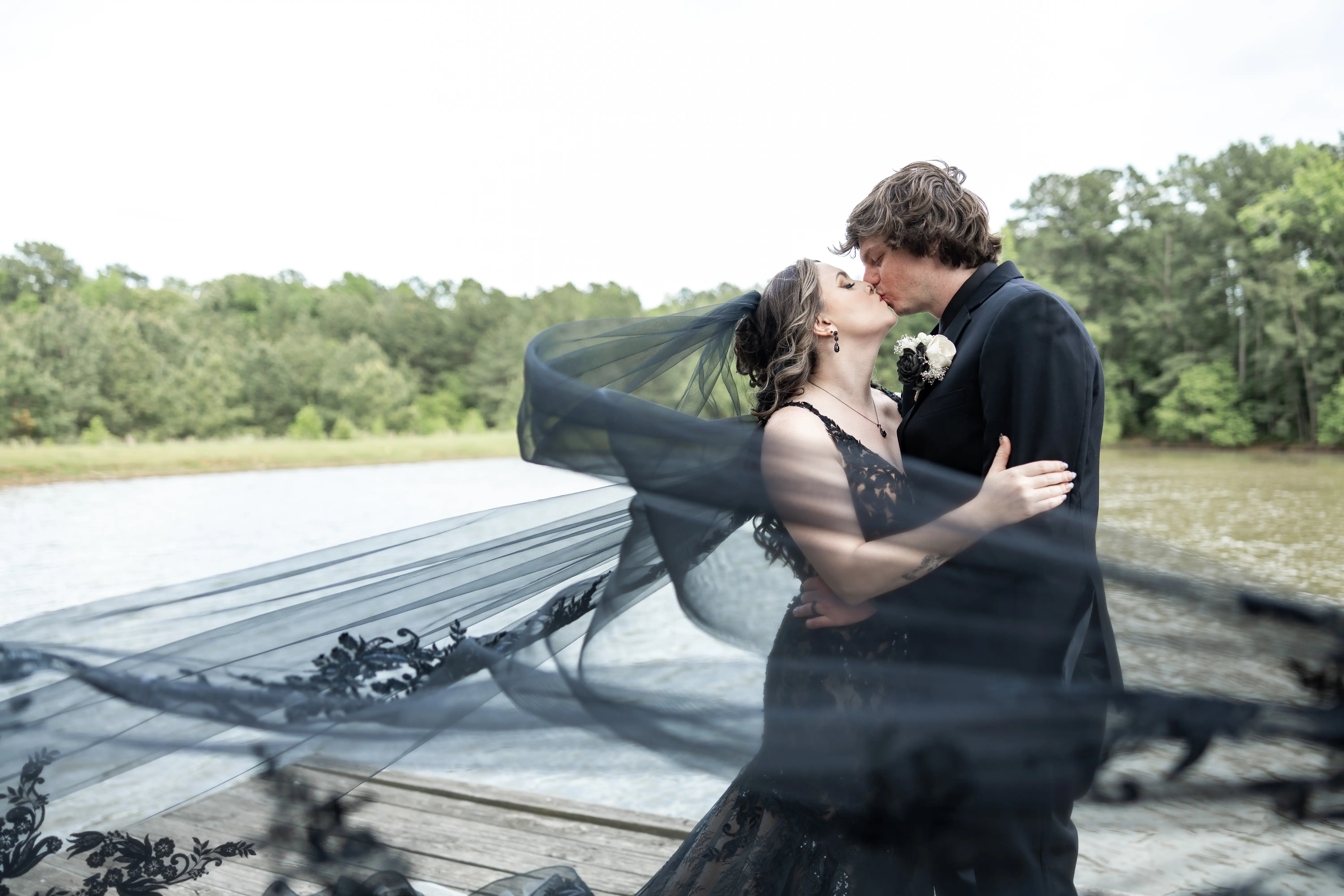 Bride wearing Zander Lane by Sottero and Midgley kissing her husband on a dock