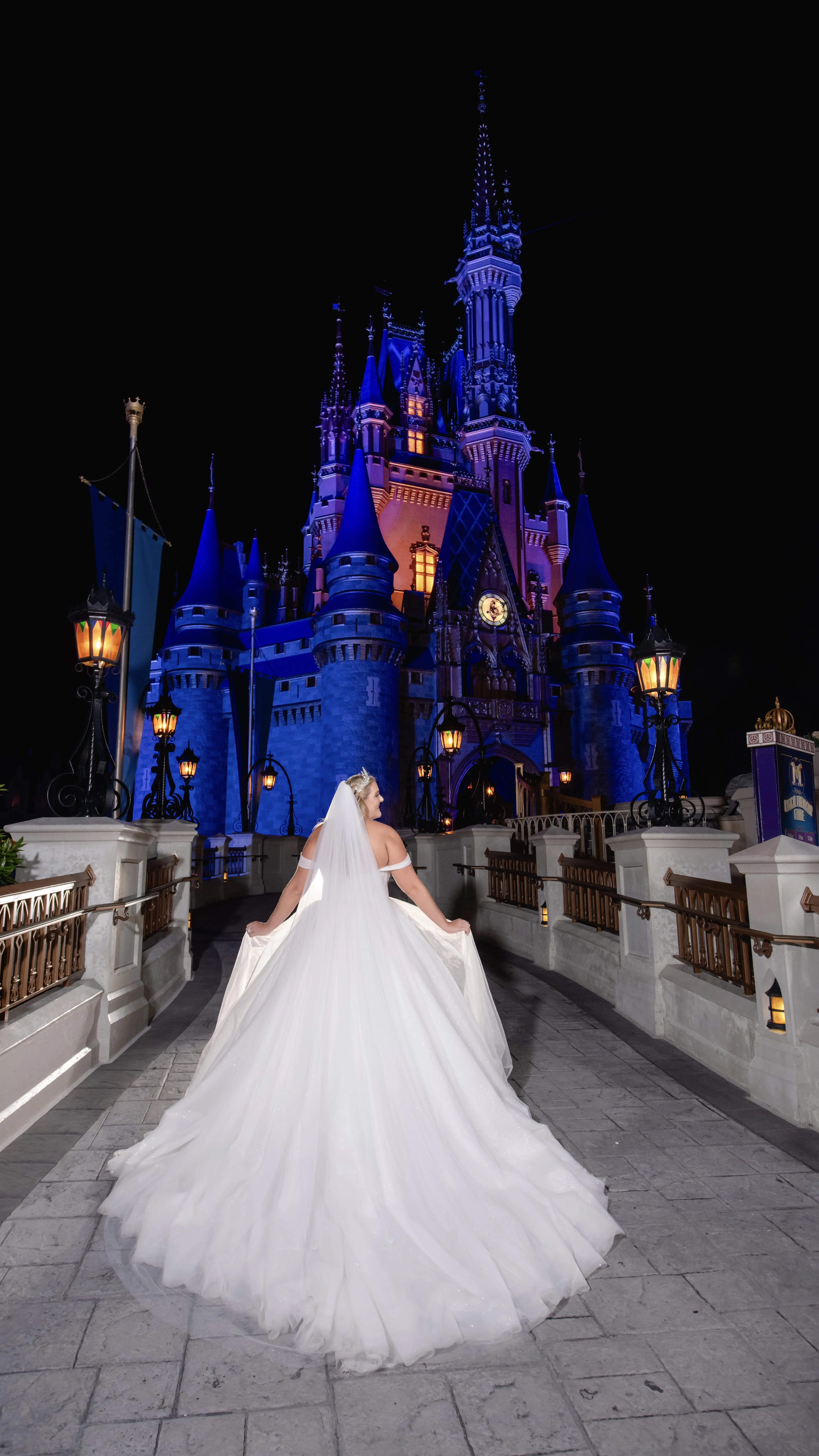Bride wearing Elton wedding dress by Sottero and Midgley in front of Disney castle