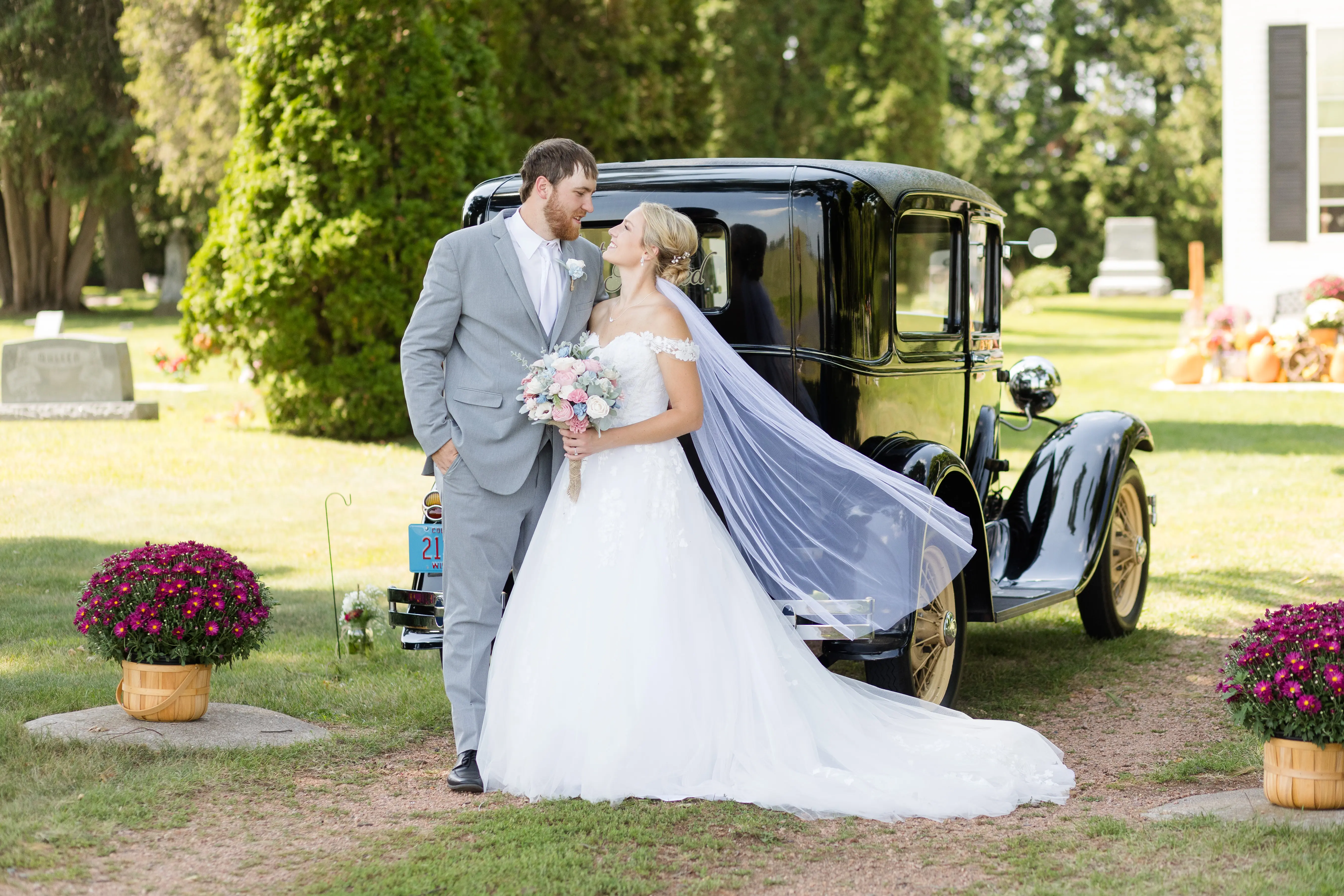 Bride Wearing Ballgown Wedding Dress Called Harlem By Maggie Sottero With Groom Next To Vintage Car