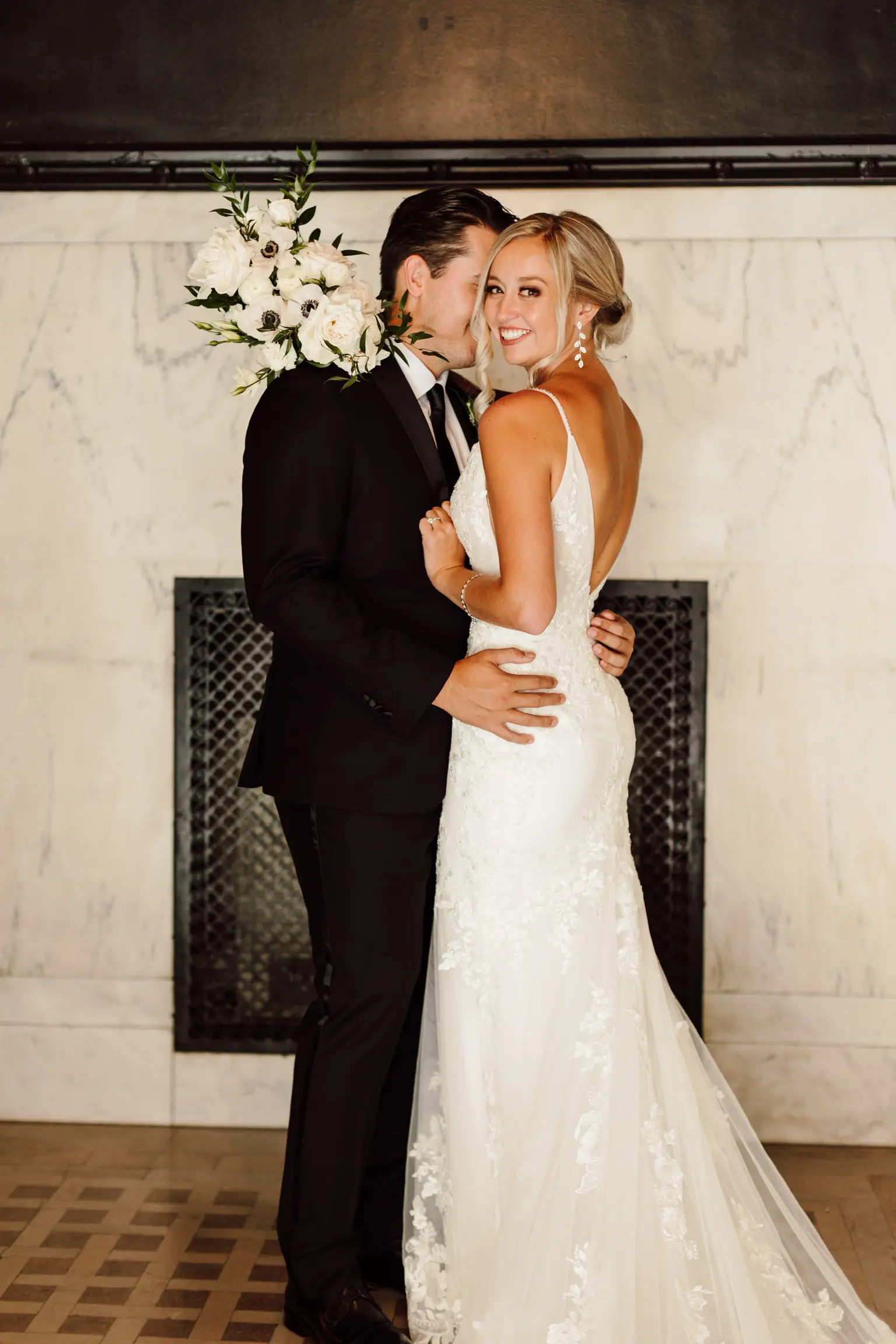 Bride Wearing Sparkle Lace Wedding Dress Called Fontaine By Maggie Sottero Looking Back Holding Flower Bouquet