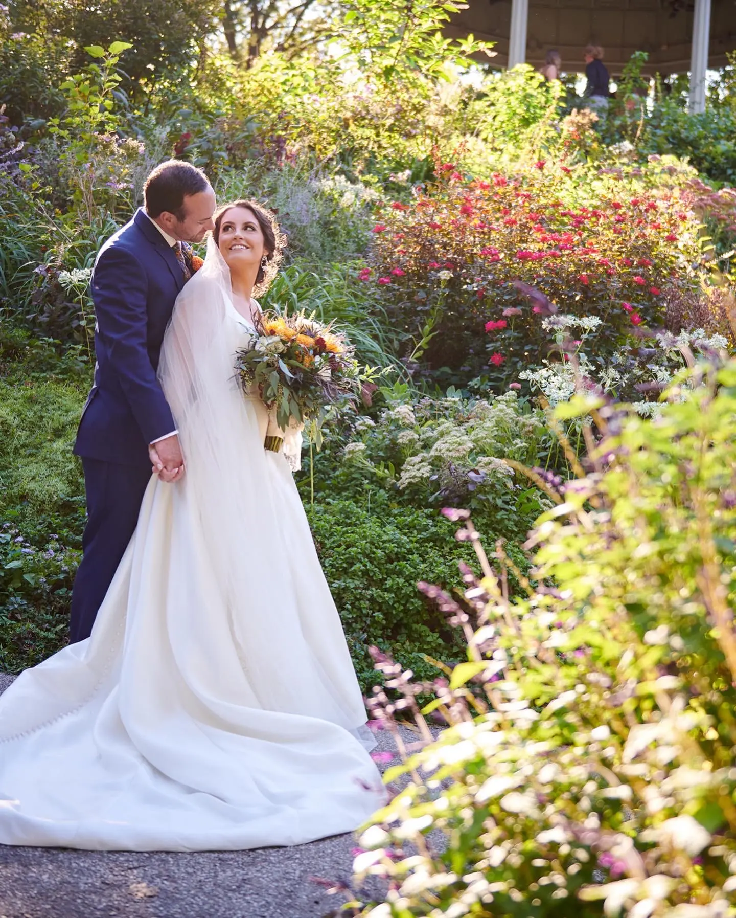 Bride Wearing Simple A-Line Bridal Gown Called Selena By Maggie Sottero With Groom In A Garden