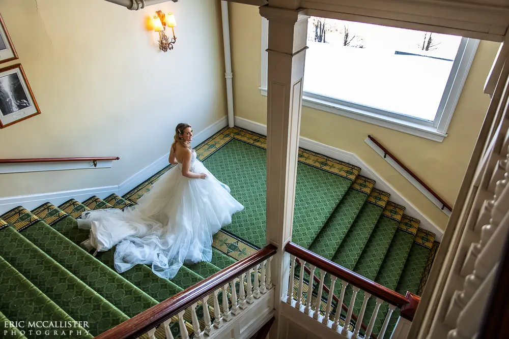 Bride wearing strapless ballgown tulle wedding dress with sweetheart neckline indoors.