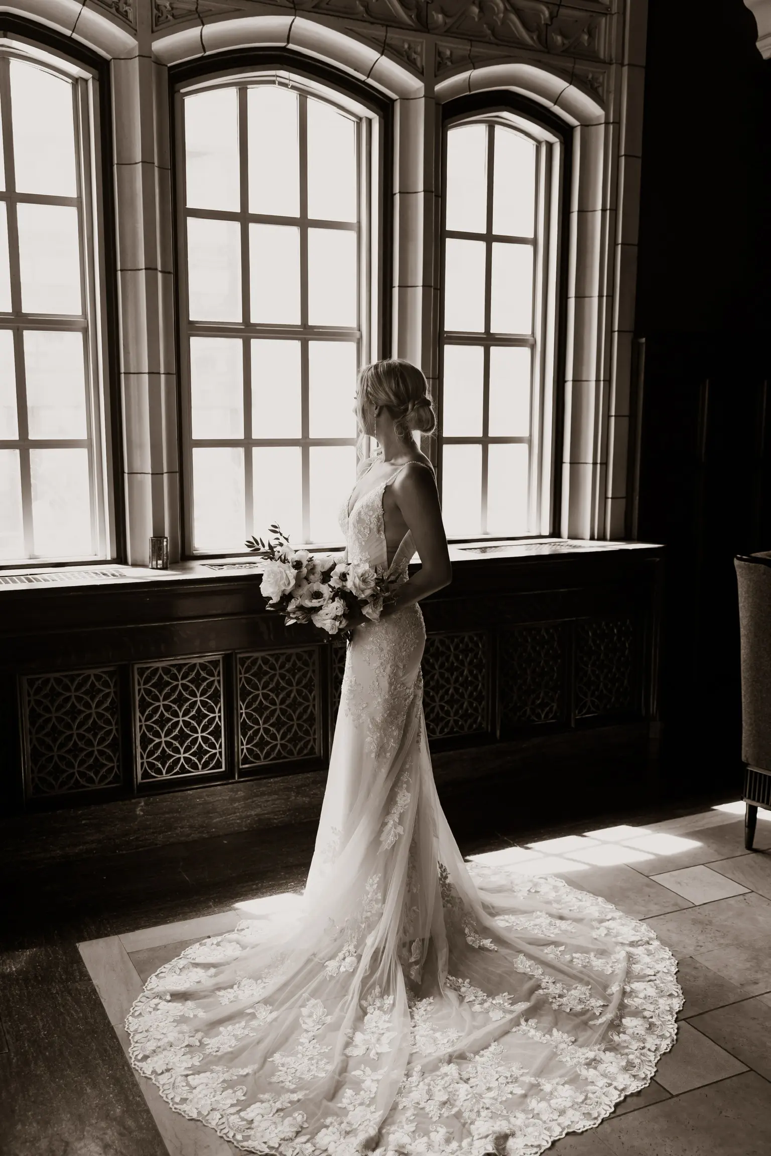 Bride Wearing Sparkle Lace Long Train Wedding Dress Called Fontaine By Maggie Sottero Looking Out Windows Sepia