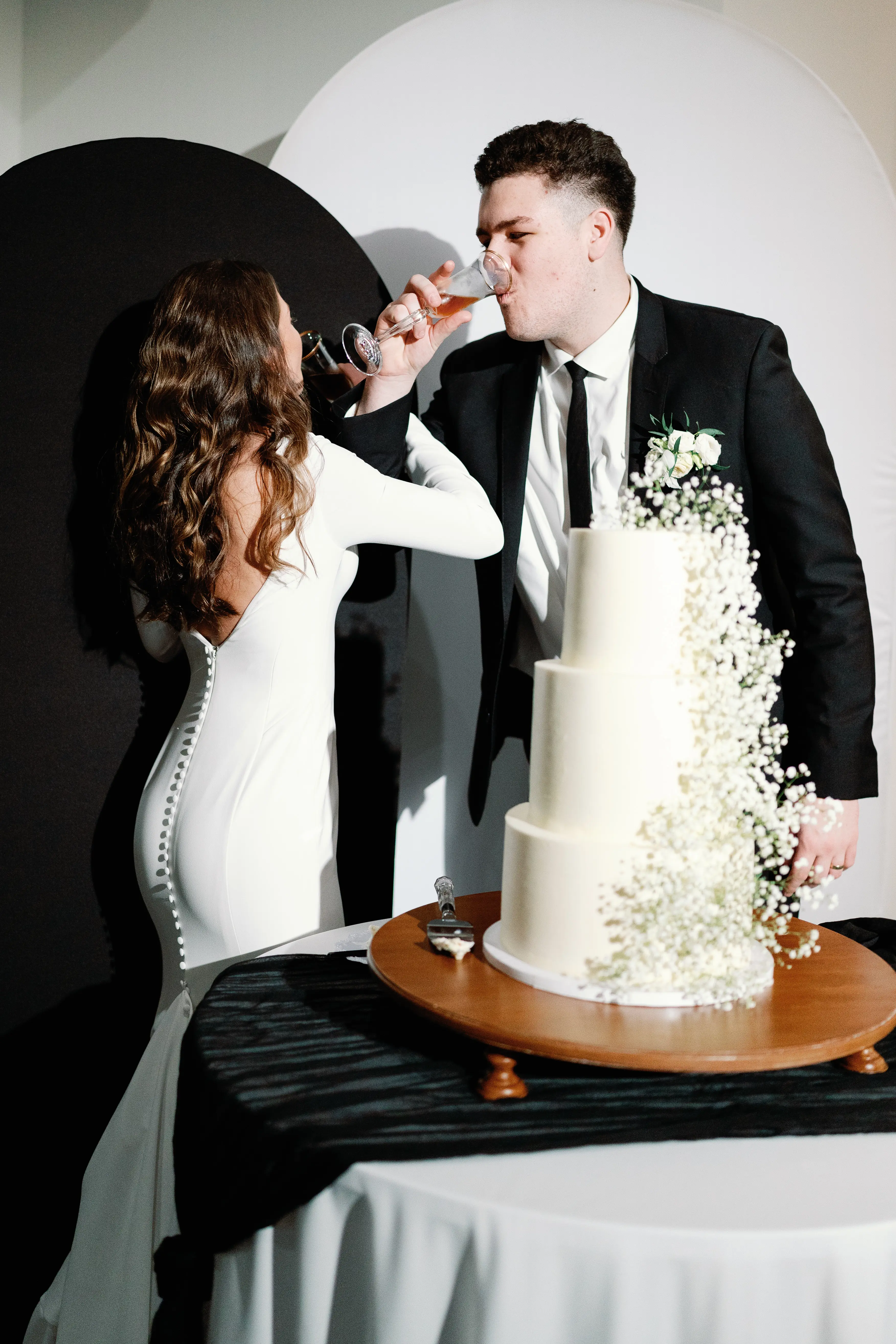 Bride wearing Fernanda wedding dress by Maggie Sottero drinking champaign with her husband