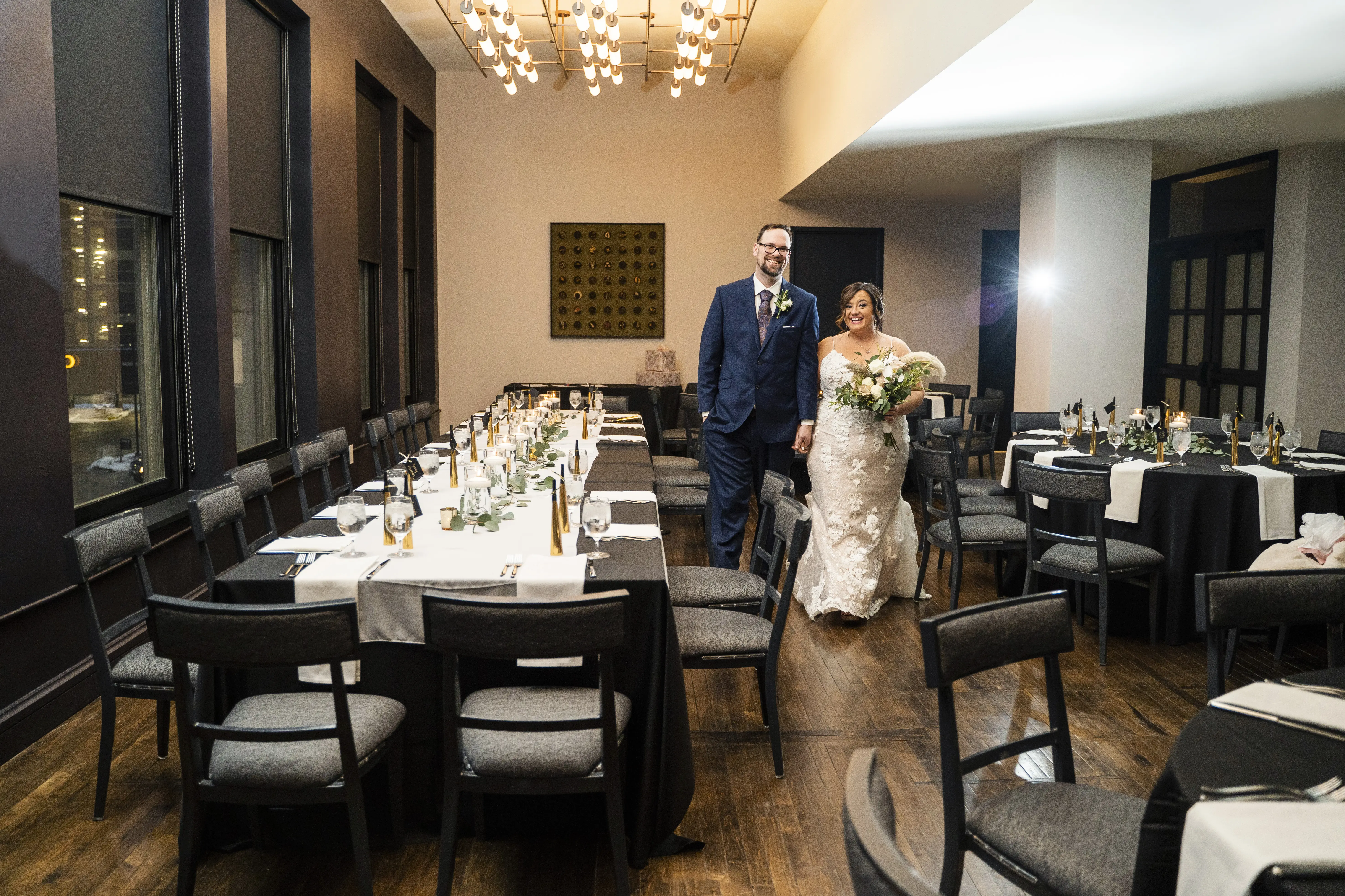 Bride and Groom Walking Into Reception Area Holding Hands Wearing Wedding Dress Called Tuscany Marie by Maggie Sottero