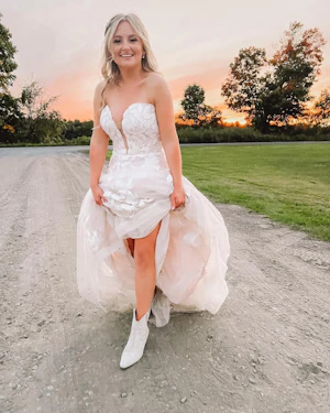 Bride in floral, lace wedding dress called Hattie by Rebecca Ingram with boots