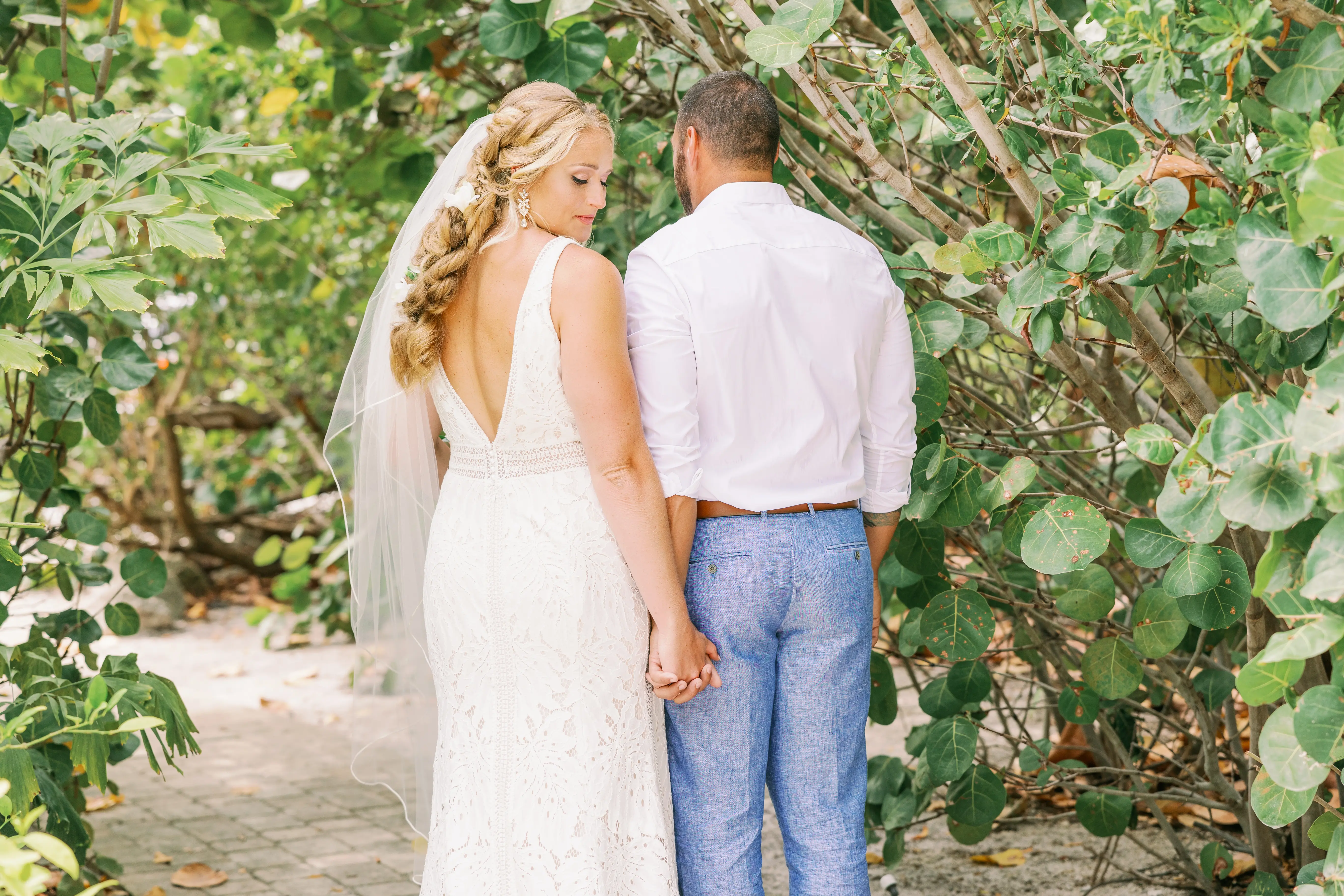 Bride looking behind her holding hands with her groom wearing wedding dress called Burke.