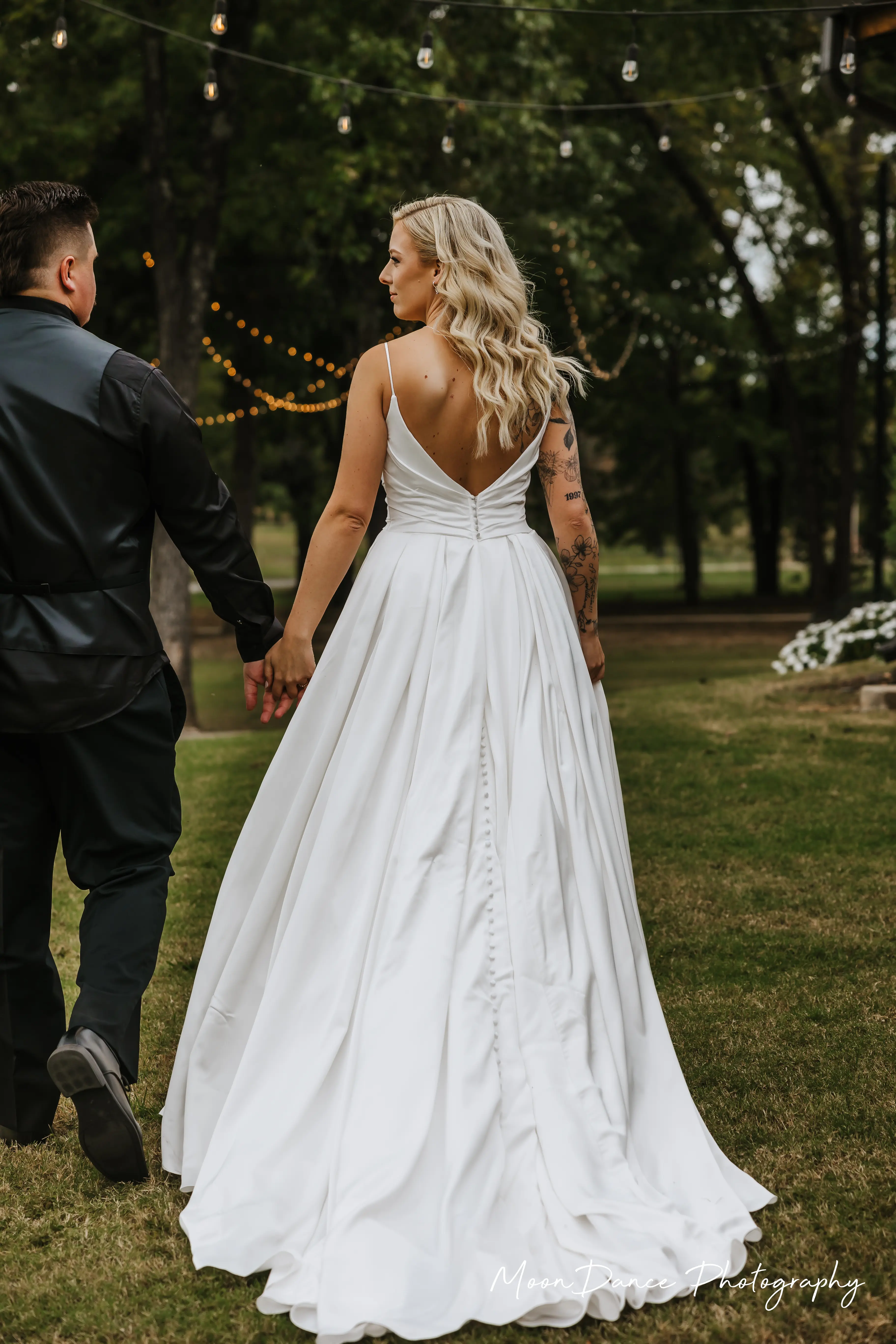 Bride Wearing Aline Satin Wedding Gown Called Scarlet By Maggie Sottero Walking Hand In Hand With Groom