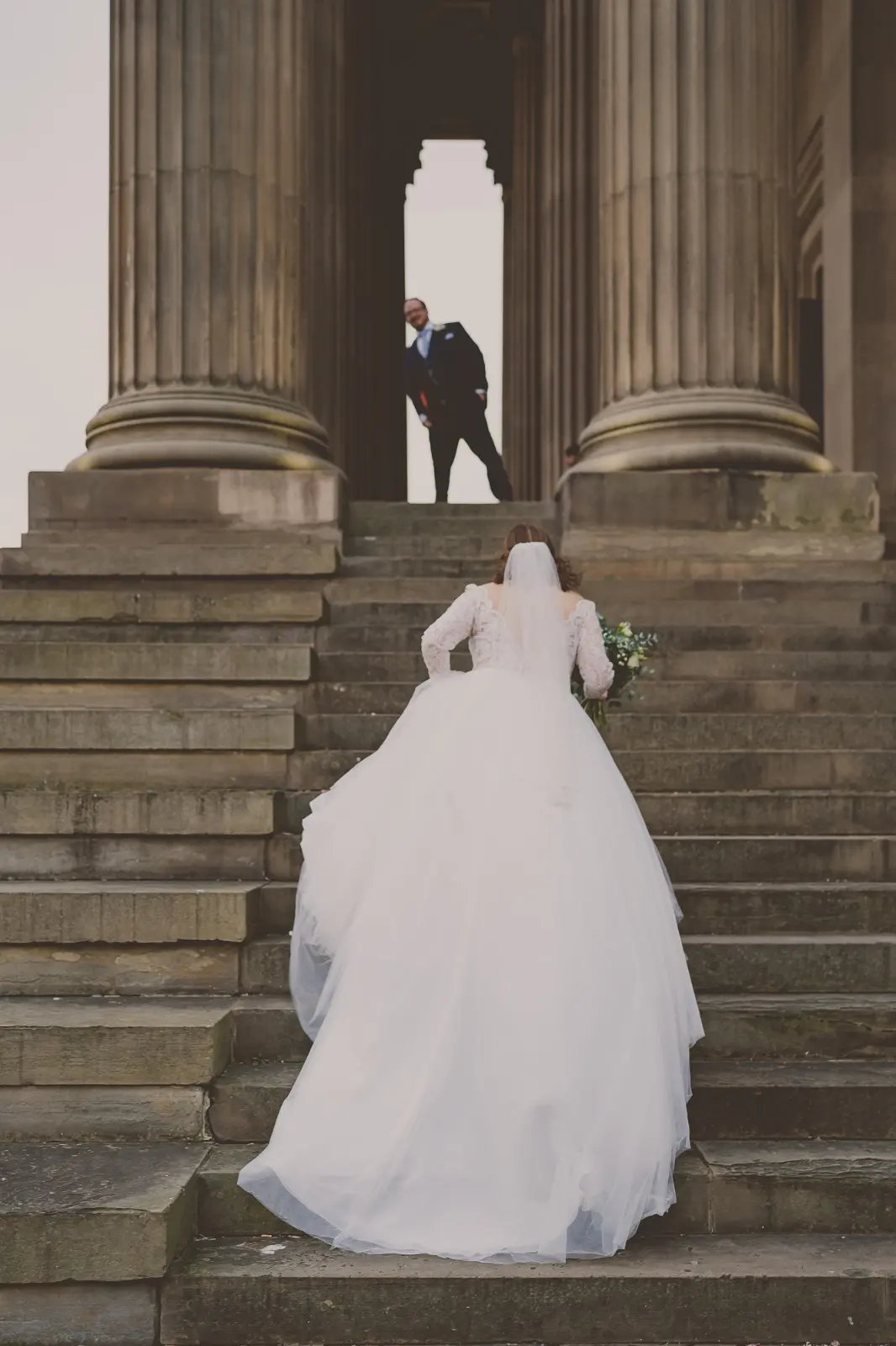 Bride Wearing Dreamy Long Sleeve Ballgown Wedding Dress Called Mallory Dawn By Maggie Sottero Walking Up Stairs To Meet Groom