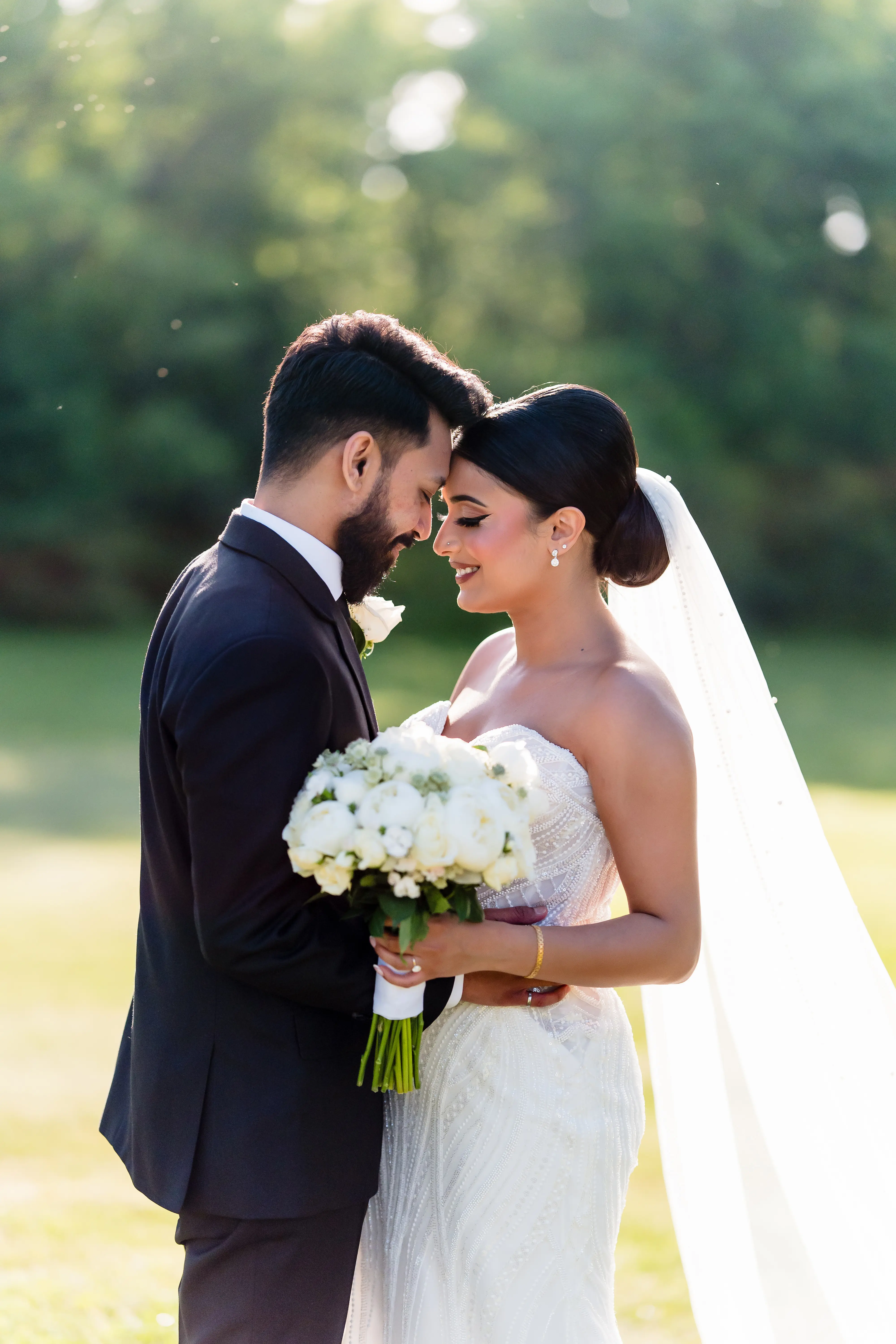 Groom Posing With Bride In Beaded Wedding Dress Named Positano By Sottero And Midgley With Long Veil And Flowers