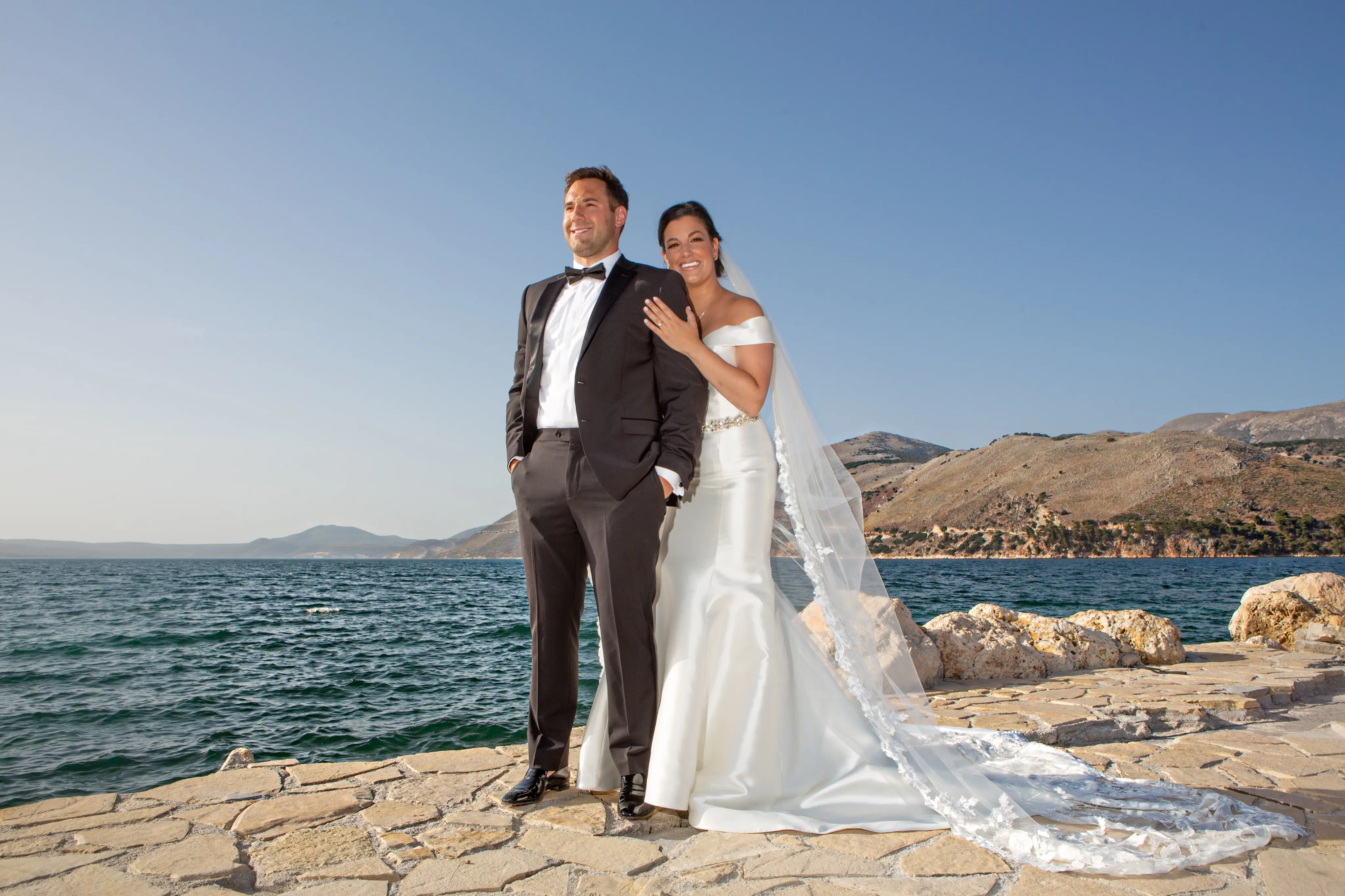 Bride wearing Simple Fit-and-Flare Wedding Dress called Josie by Rebecca Ingram on the beach with the groom