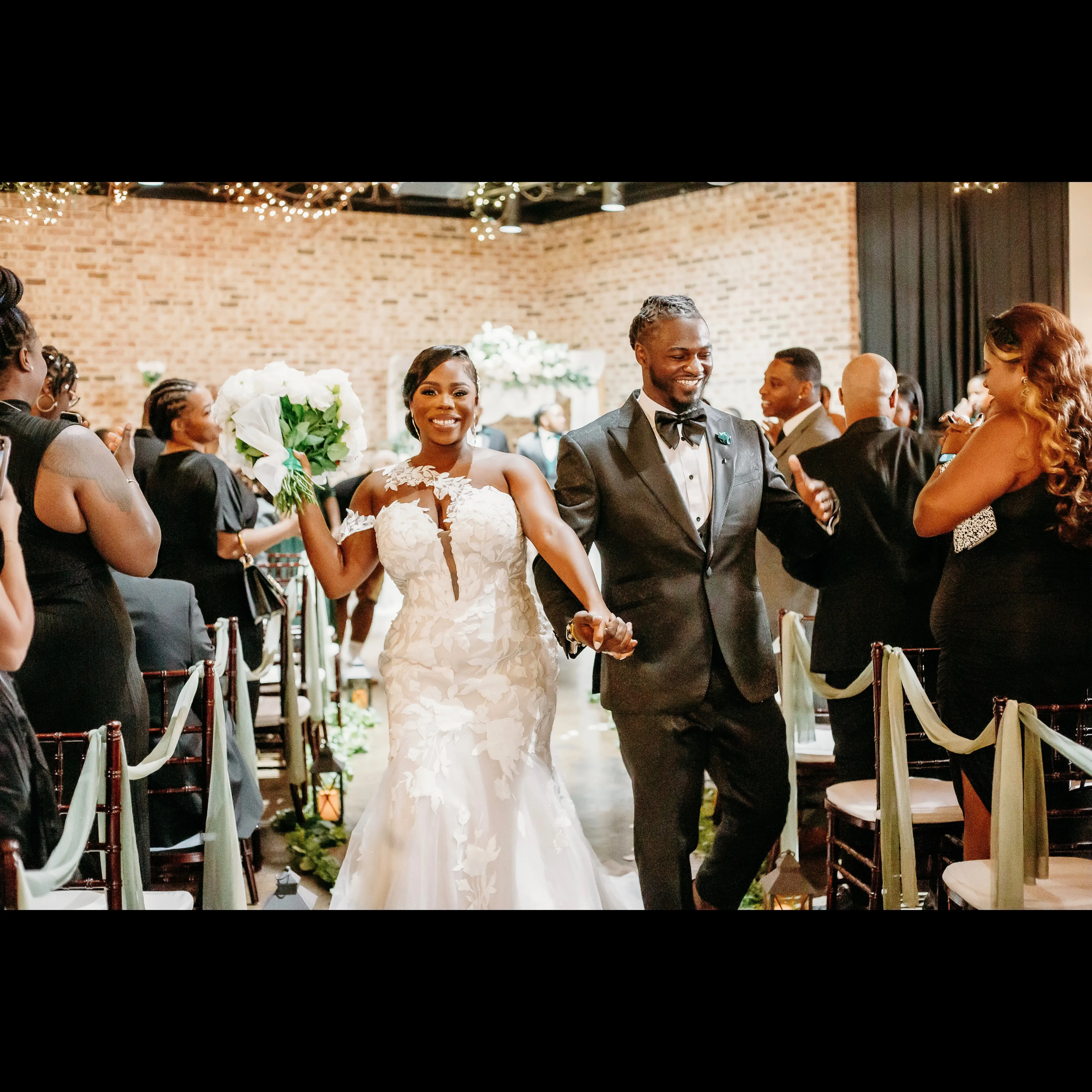 Bride wearing Hattie by Rebecca Ingram walking out of her ceremony with her husband