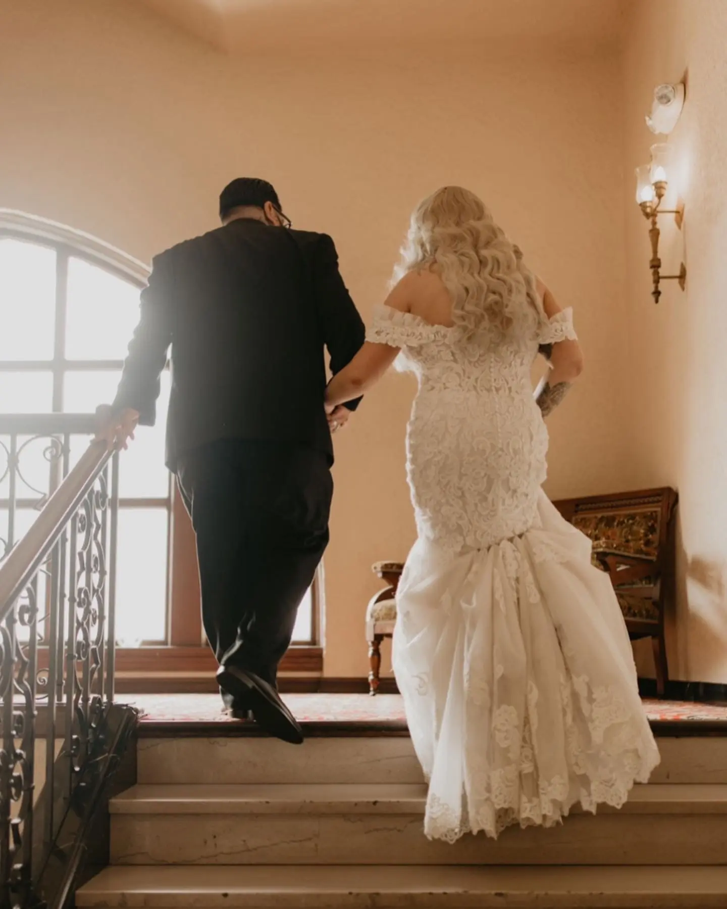 Bride Wearing Sexy Lace Wedding Dress Called Fiona By Maggie Sottero Walking Up Stairs With Groom