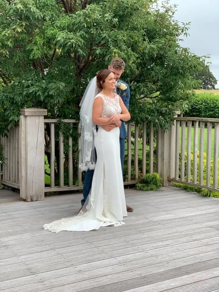 Groom hugging his bride who is wearing wedding dress called Jayleen