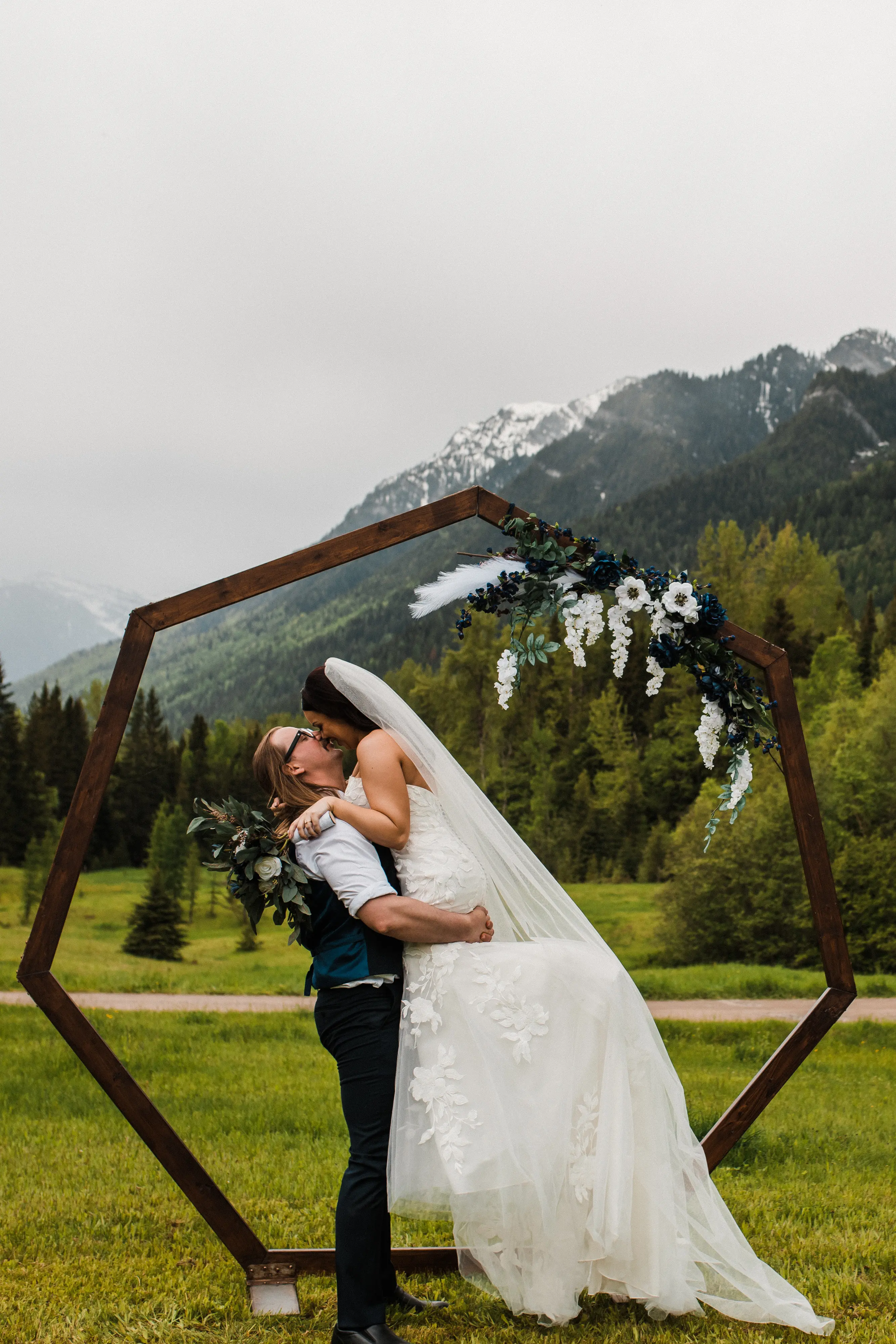 Bride Kissing Groom At The Alter In A Floral Lace Wedding Dress Called Hattie By Maggie Sottero
