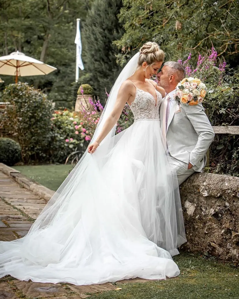 Bride leaning on her groom wearing wedding dress called Mallory.