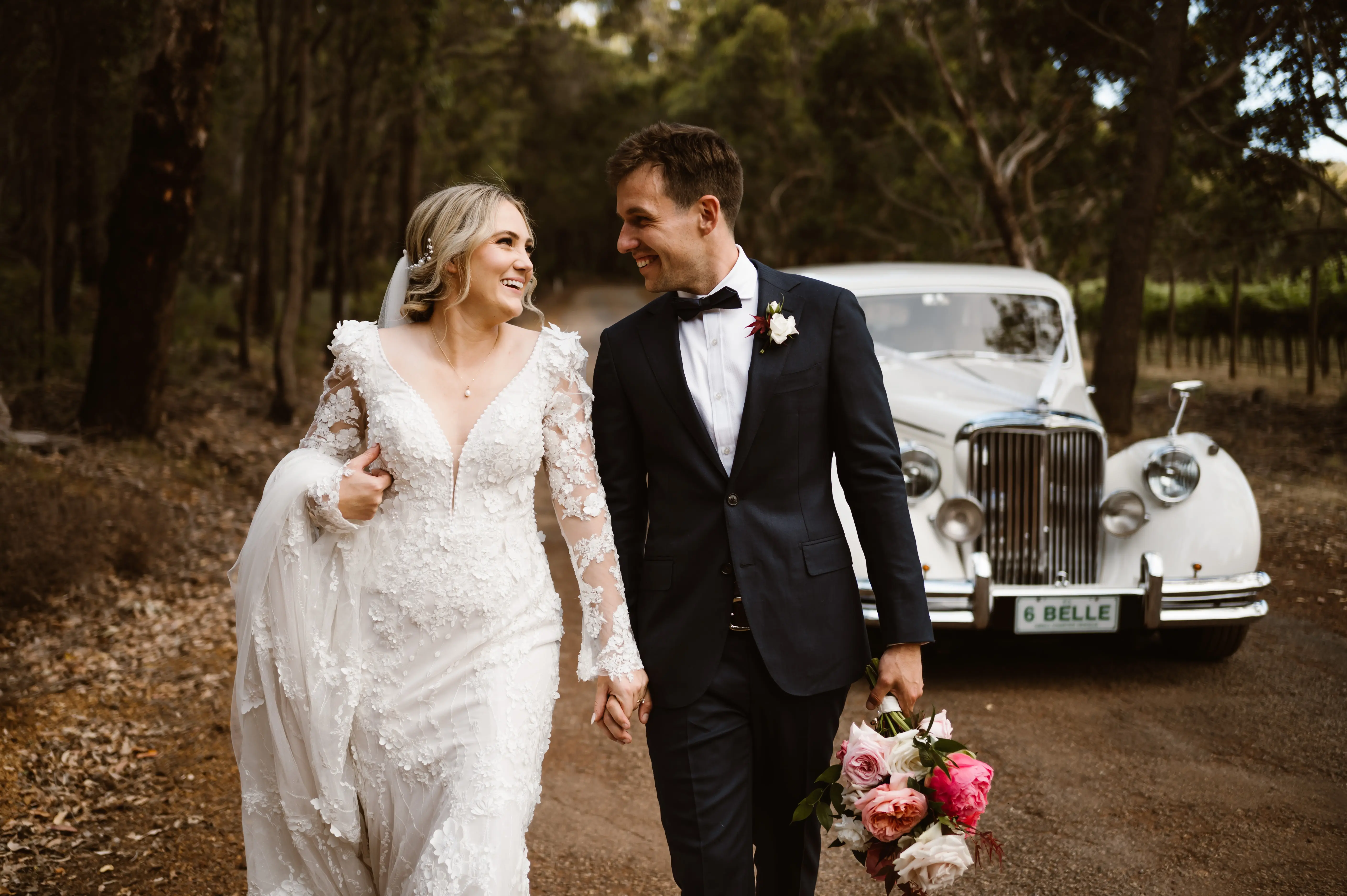 Groom Holding Hands with Bride in VIntage Inspired Puff Sleeve Mermaid Wedding Dress in 3-D Floral Motifs Called Cruz by Sottero & Midgley