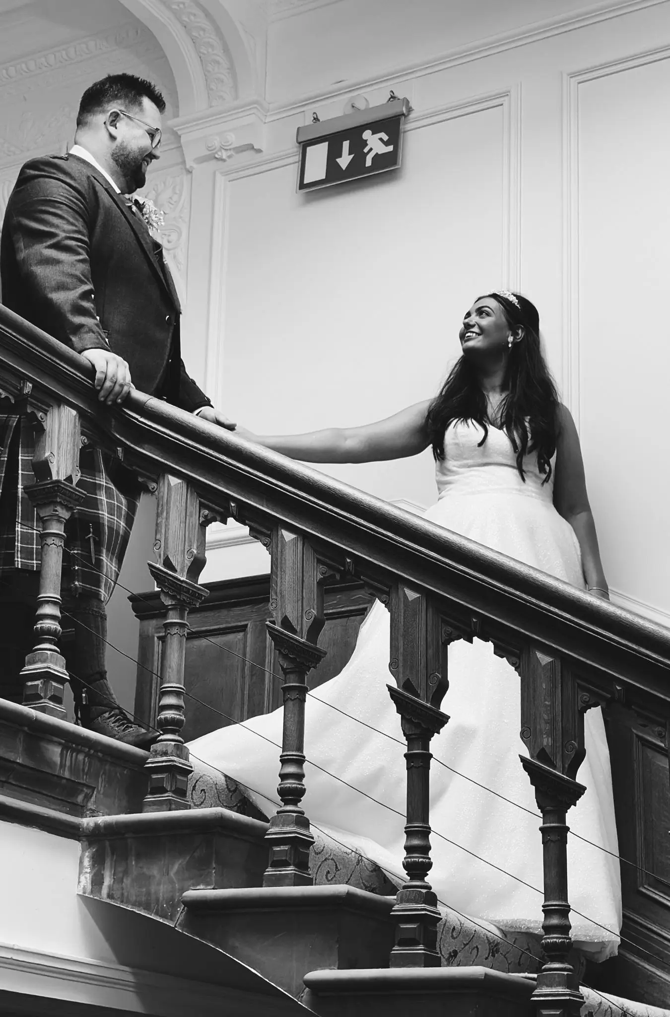 Bride wearing Anniston by Maggie Sottero walking down the stairs with her husband