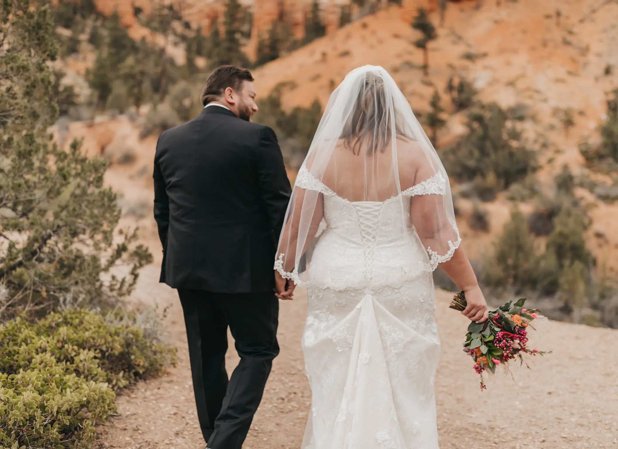 bride with groom in corset back fit and flare wedding dress