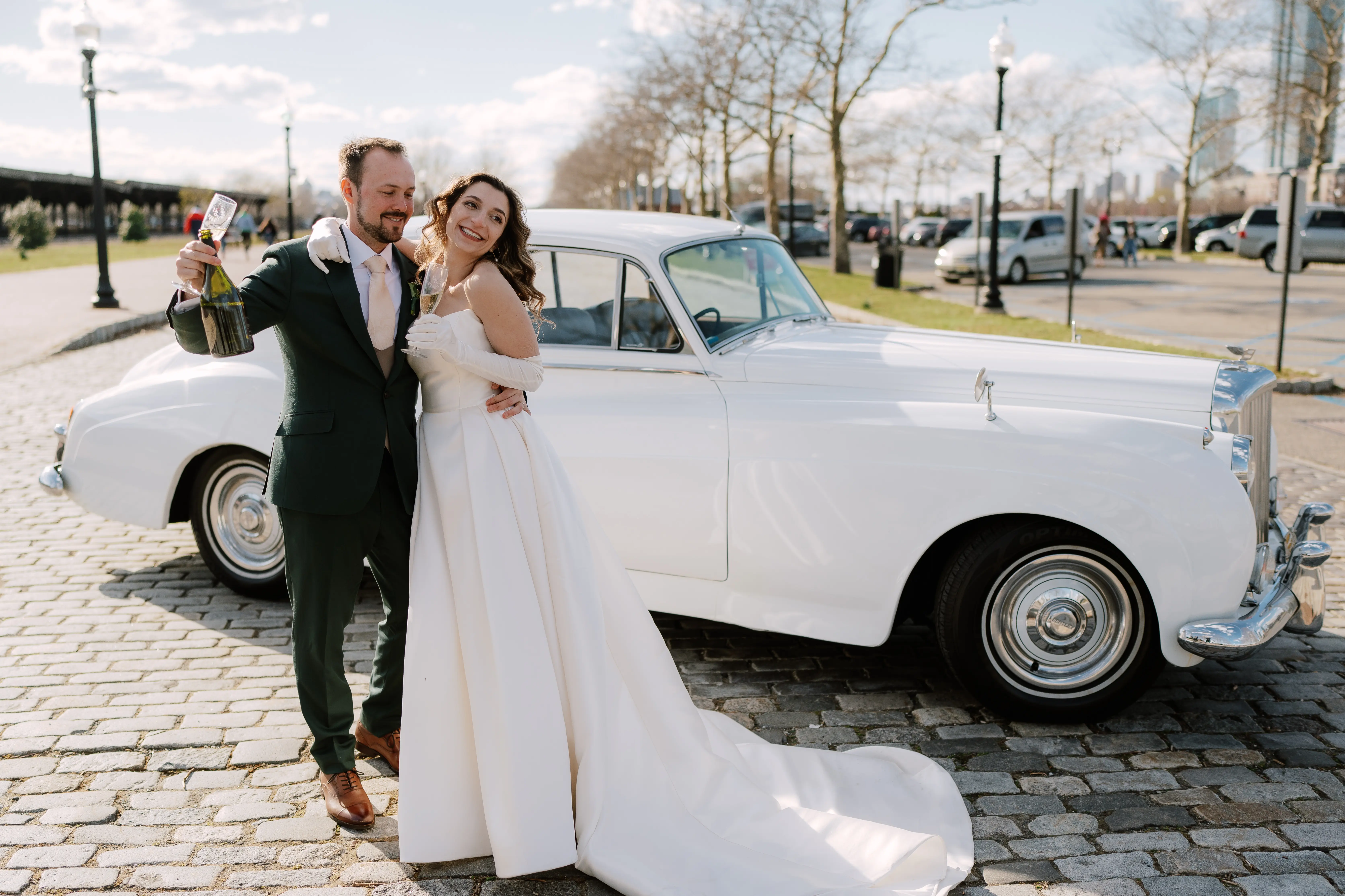 Bride wearing Selena by Maggie Sottero with her husband in front of a car