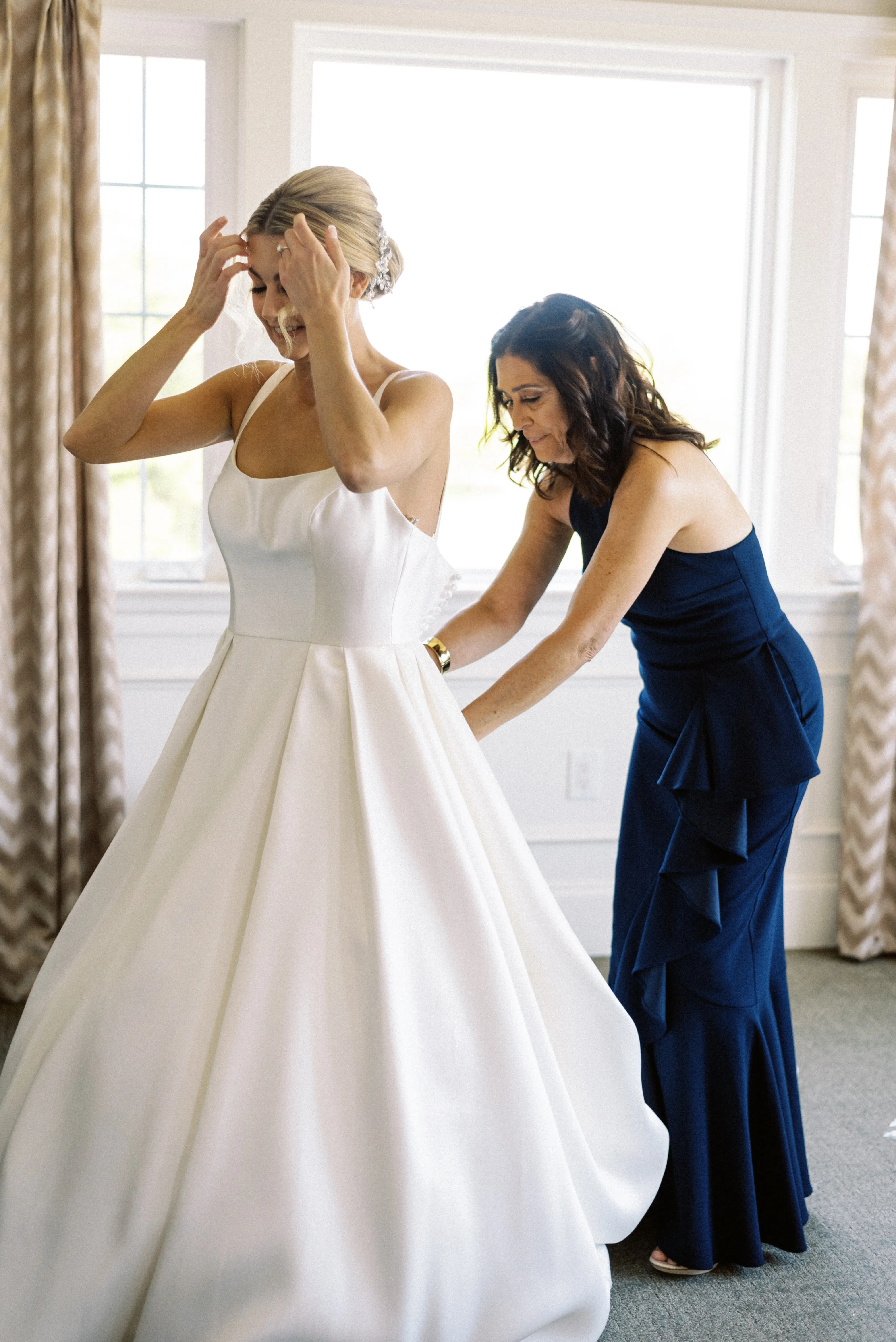 Bride wearing Selena wedding dress by Maggie Sottero being zipped up