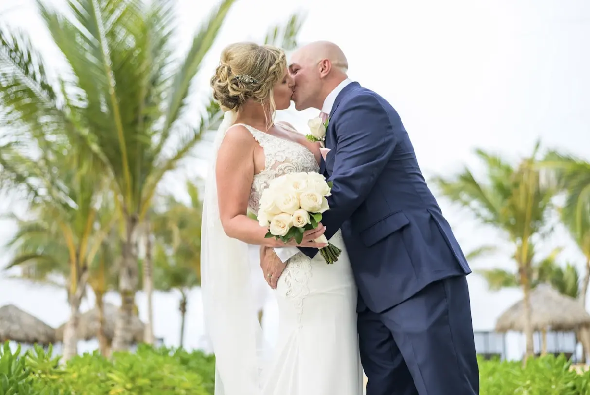Groom kissing bride wearing wedding dress called Aidan.