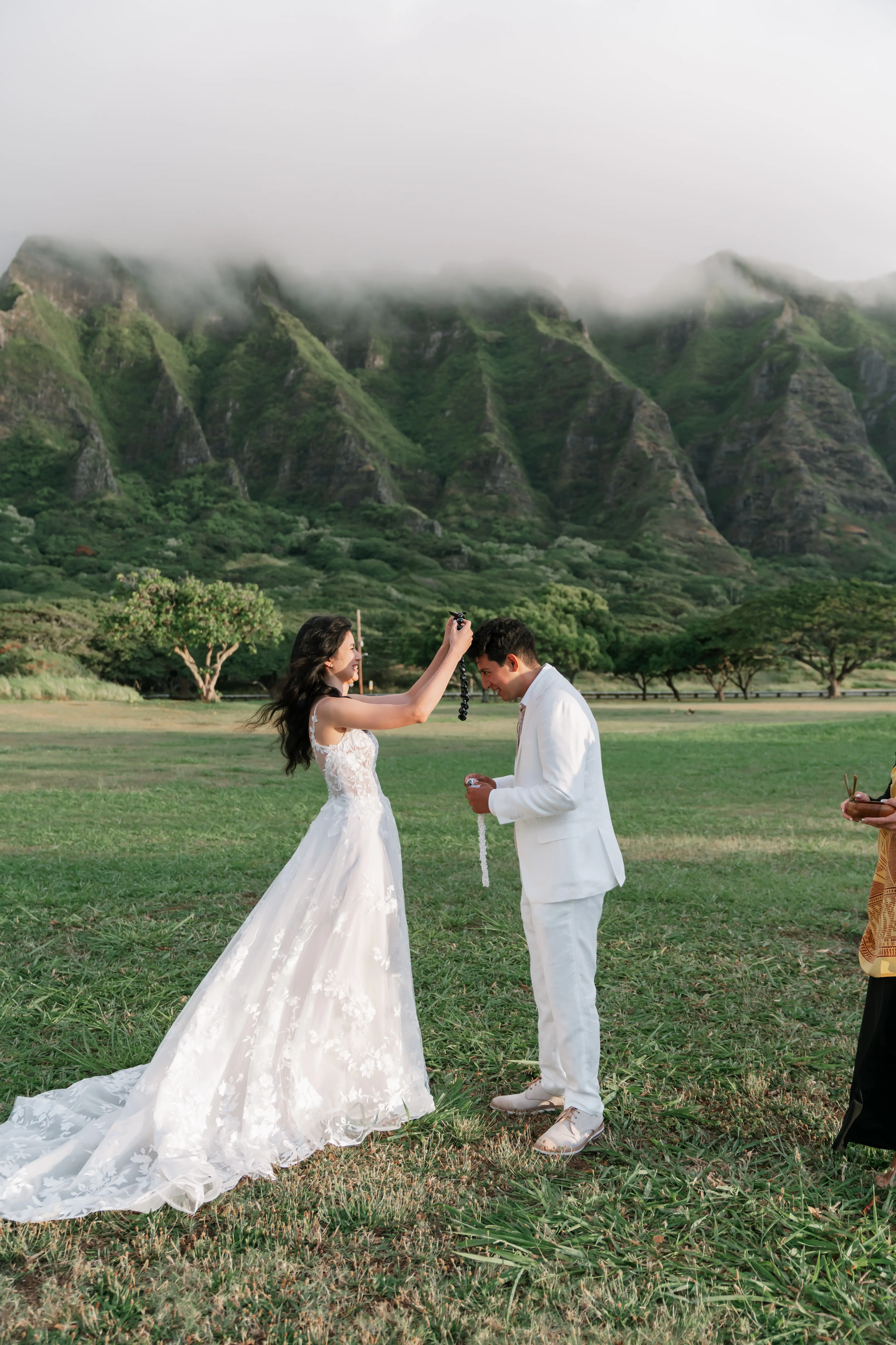 Bride wearing Winter wedding dress by Maggie Sottero puts necklace on her husband