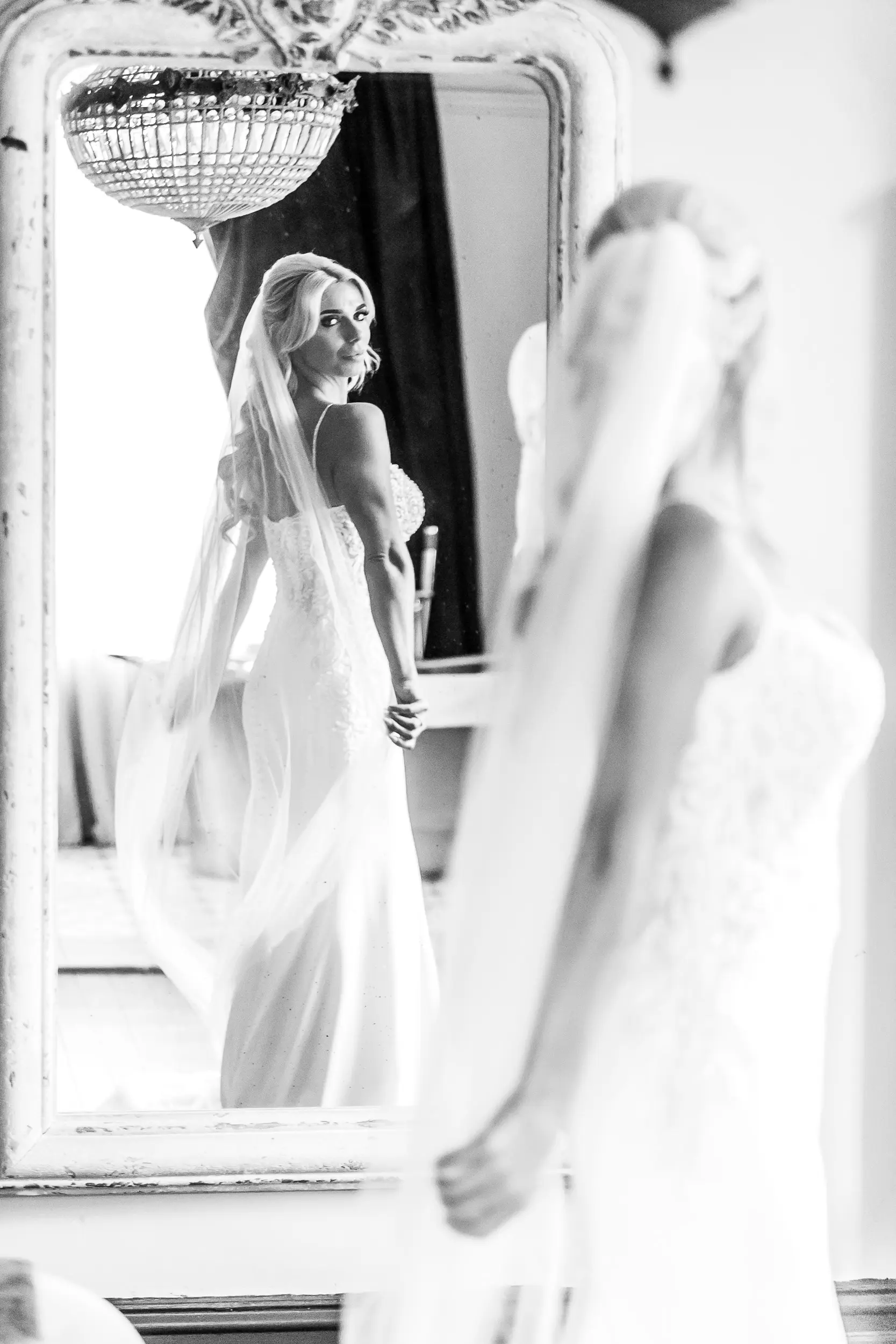 Bride looking back in to large shabby chic mirror wearing wedding dress called Juanita.