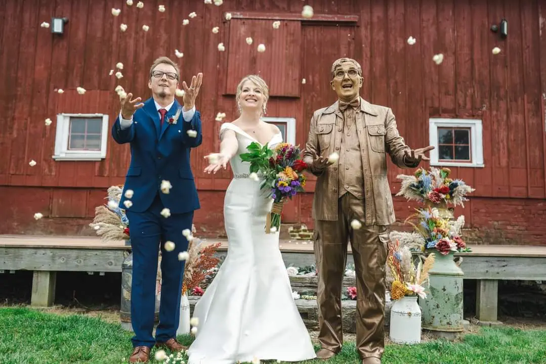 Bride wearing Josie by Rebecca Ingram with her husband throwing popcorn