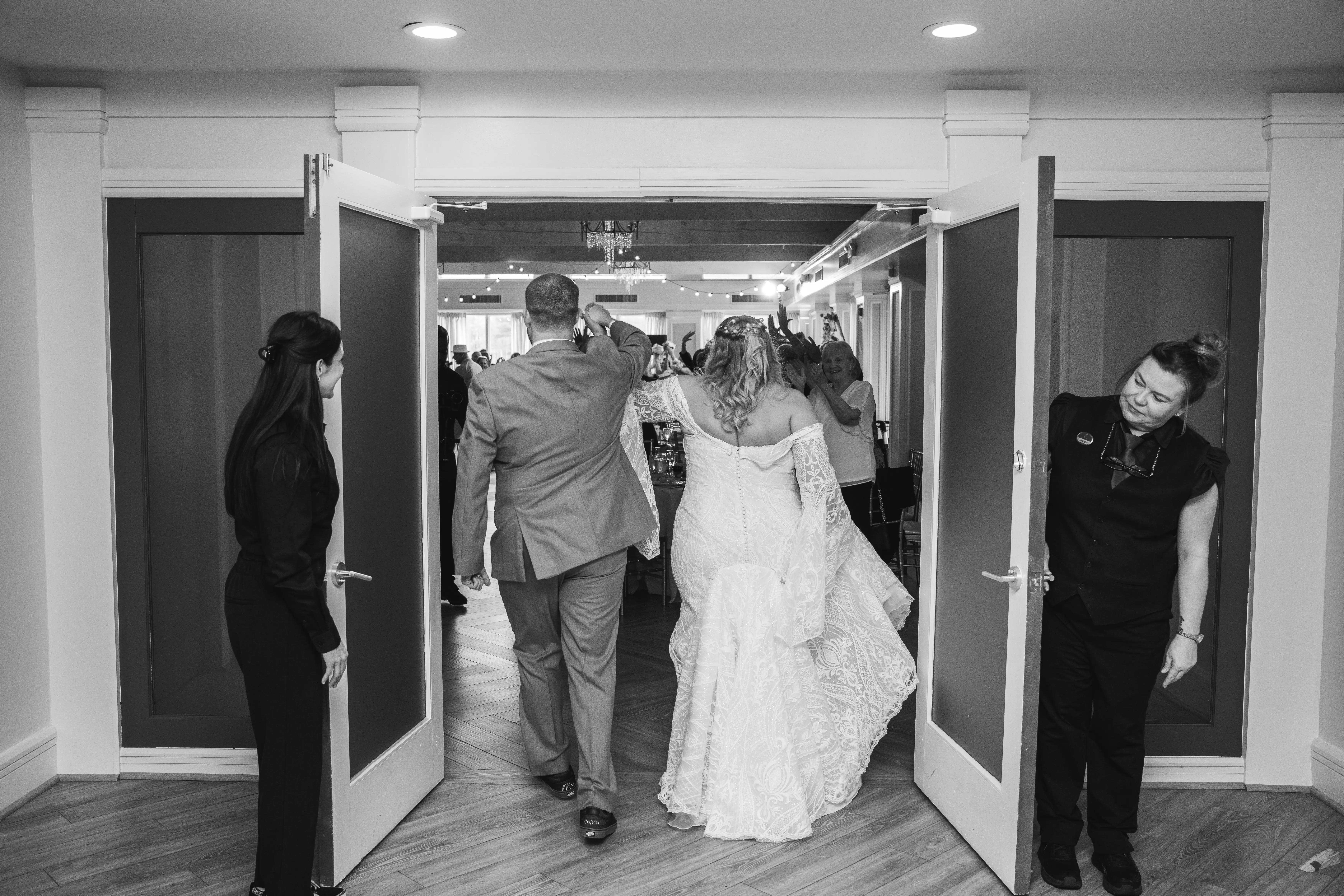 Bride wearing Bronson by Sottero and Midgley walking into her reception with her husband